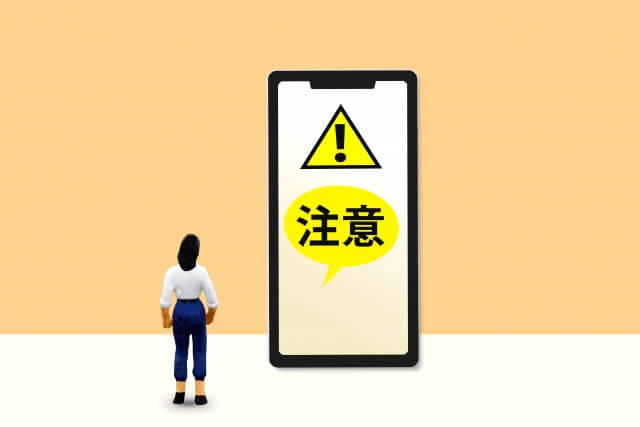携帯に注意と文字が出ている