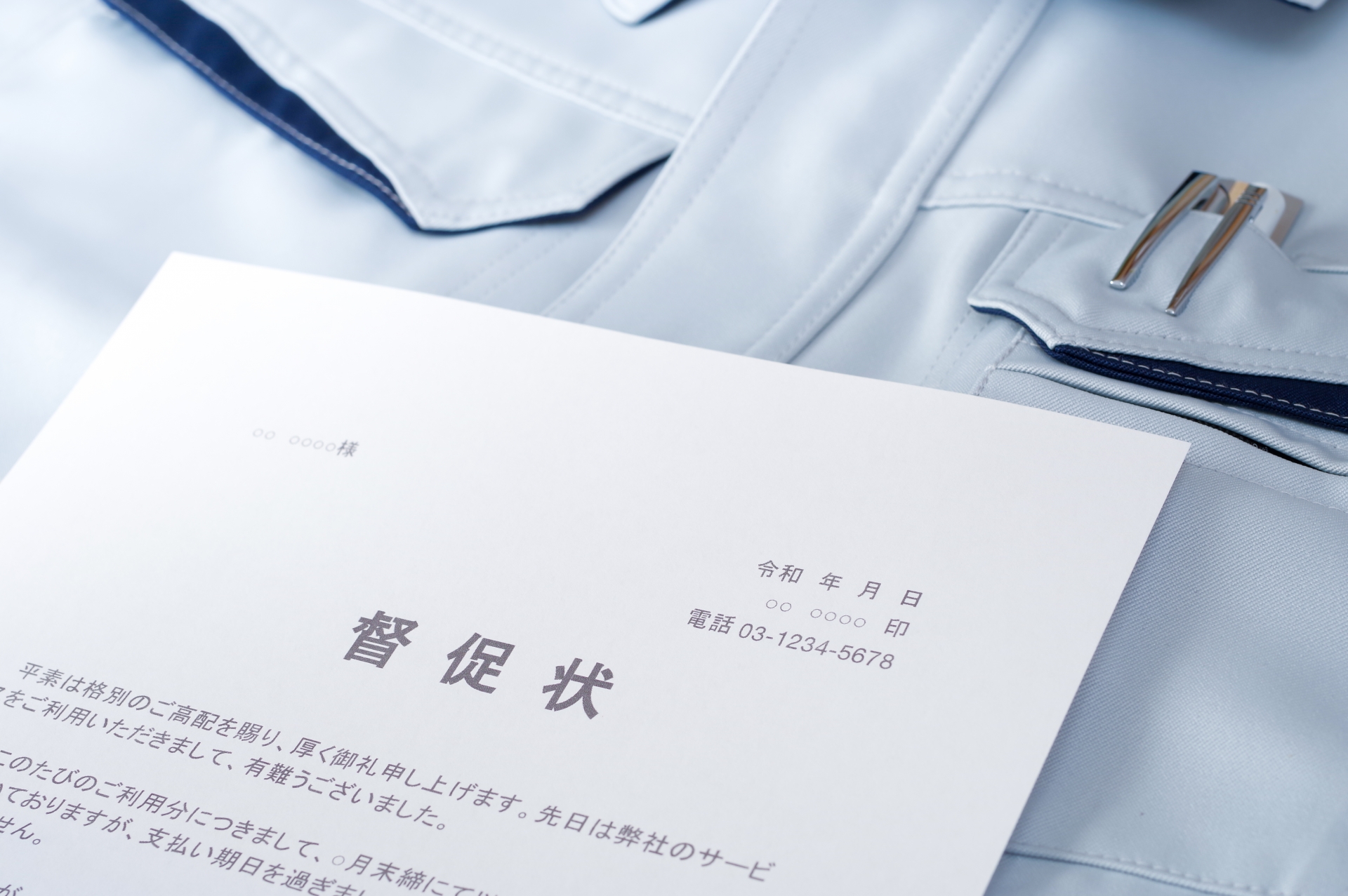 作業服の上に置かれた督促状