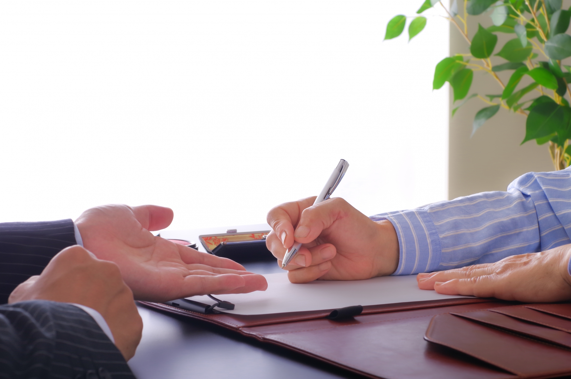 書類を記入する女性とそれを促す男性の手元