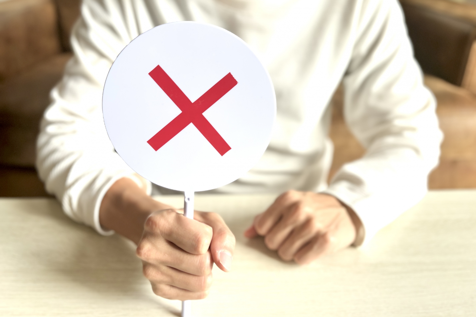 バツのプラカードを持つ男性