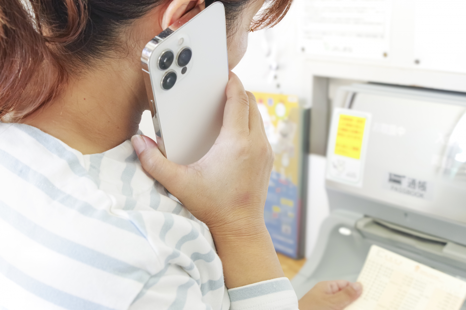 通話しながら銀行ATMを操作する女性