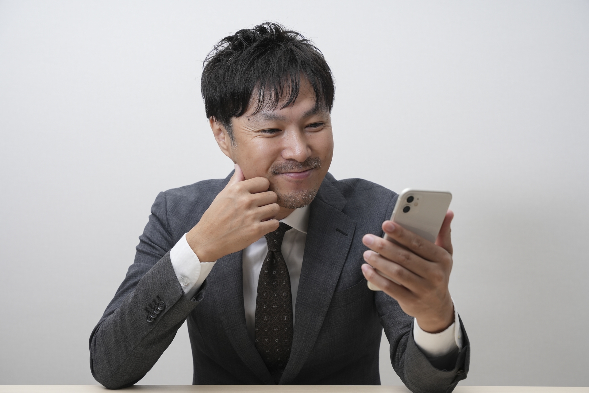 グレースーツのビジネスマンとケータイ