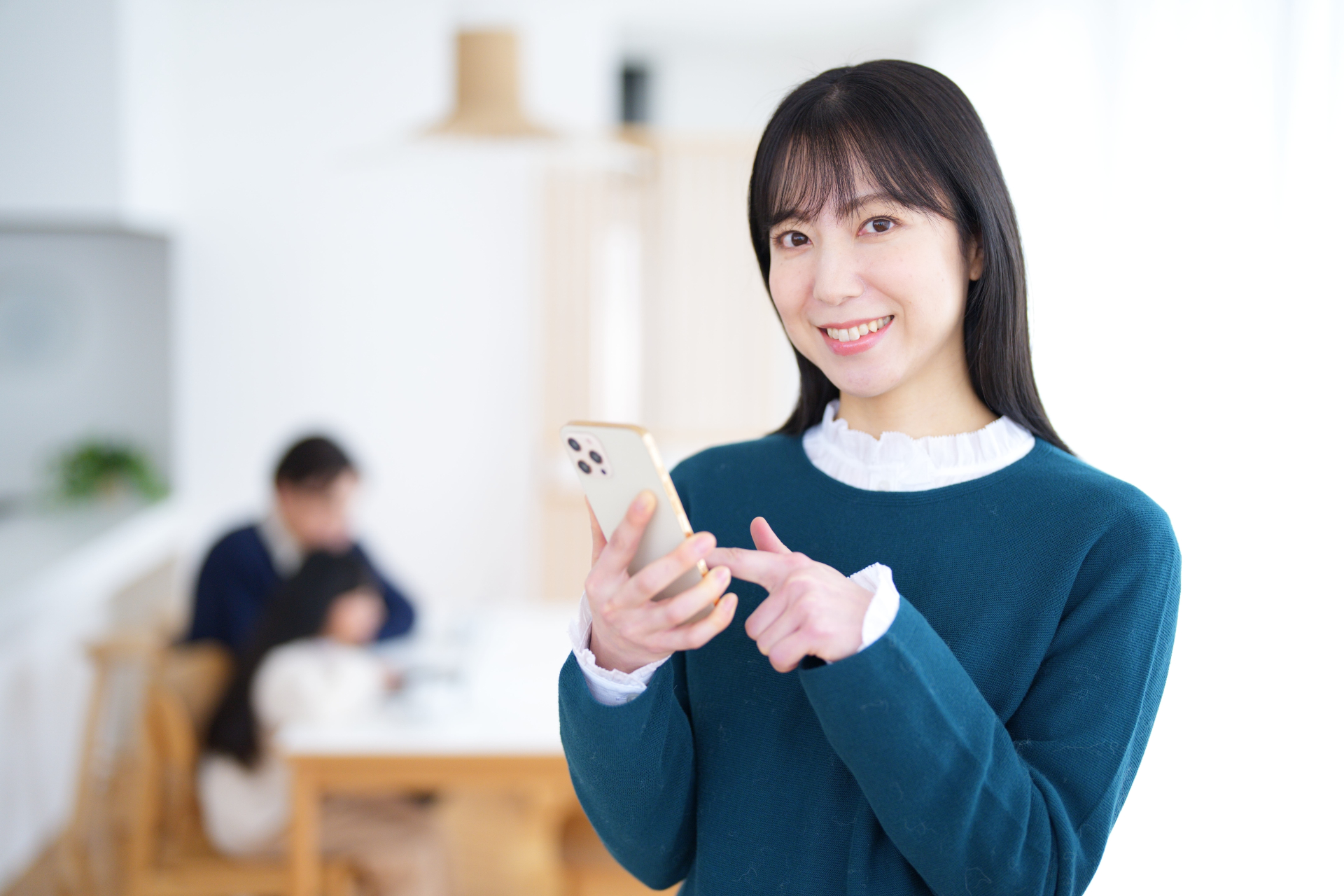 携帯を指さしてカメラ目線の女性