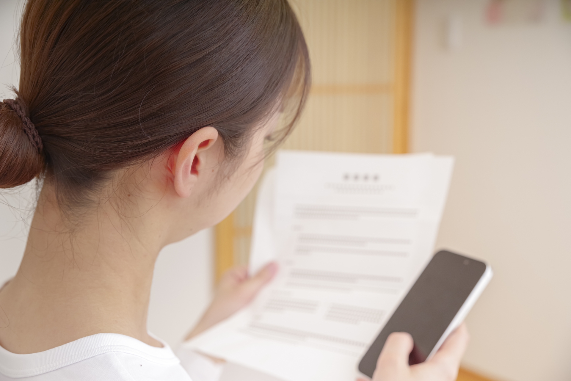 リビングで書類を確認する女性