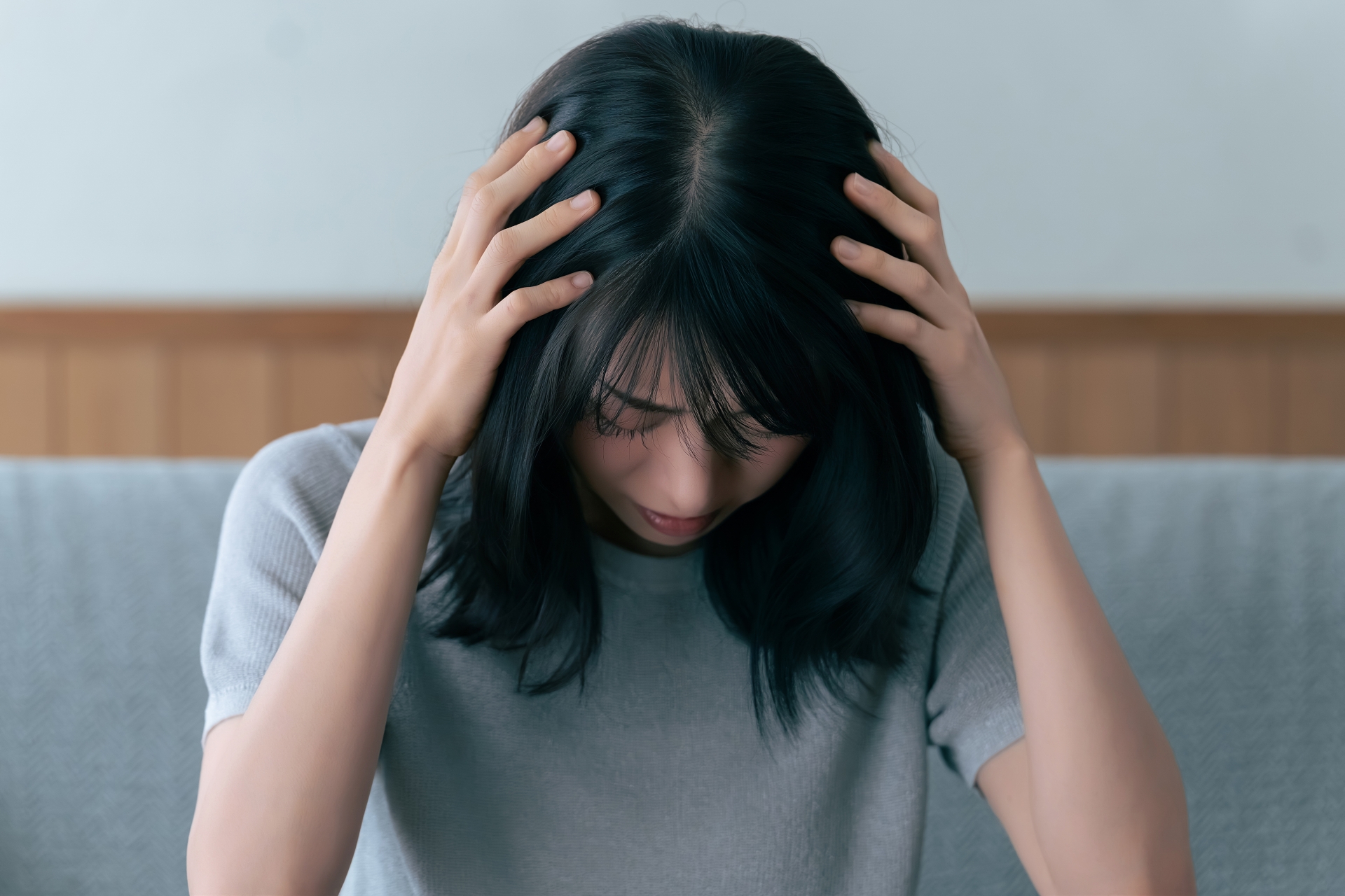 頭を抱えて悩む女性