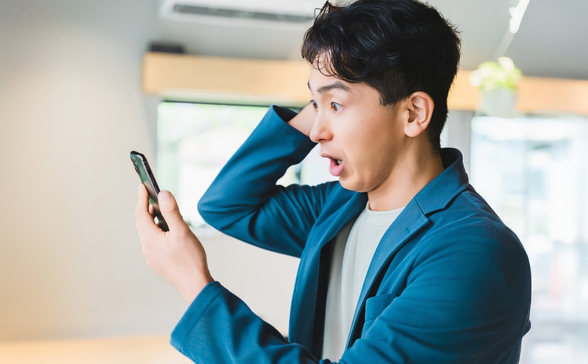 スマホを見て驚く男性ビジネスマン