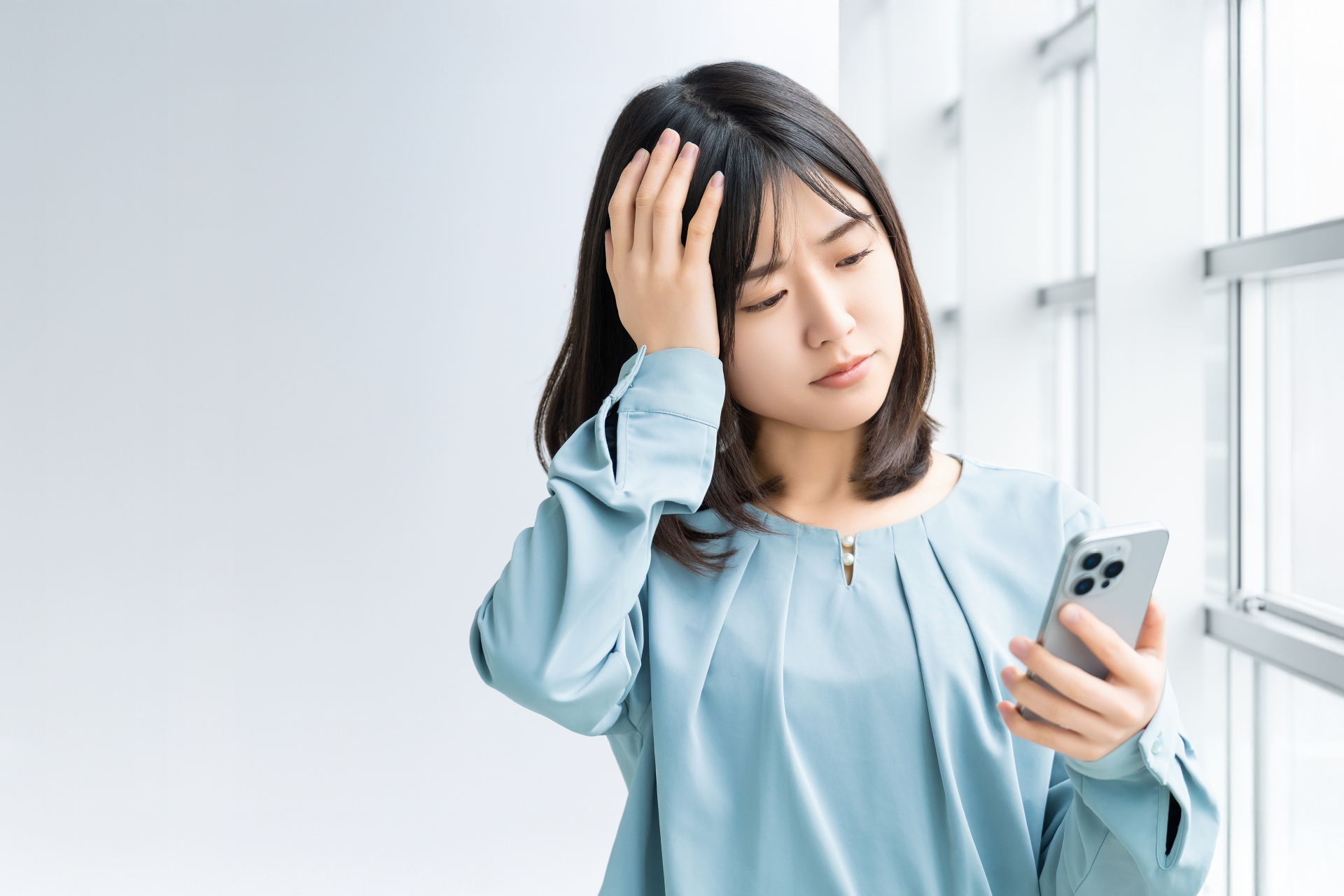 スマホを見て考える女性・ビジネスウーマン