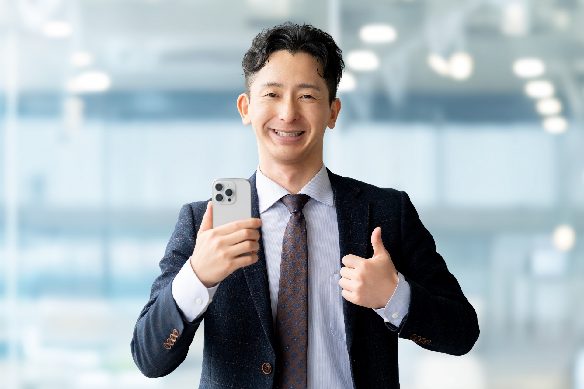 スマホを持っていいね！のポーズをする男性