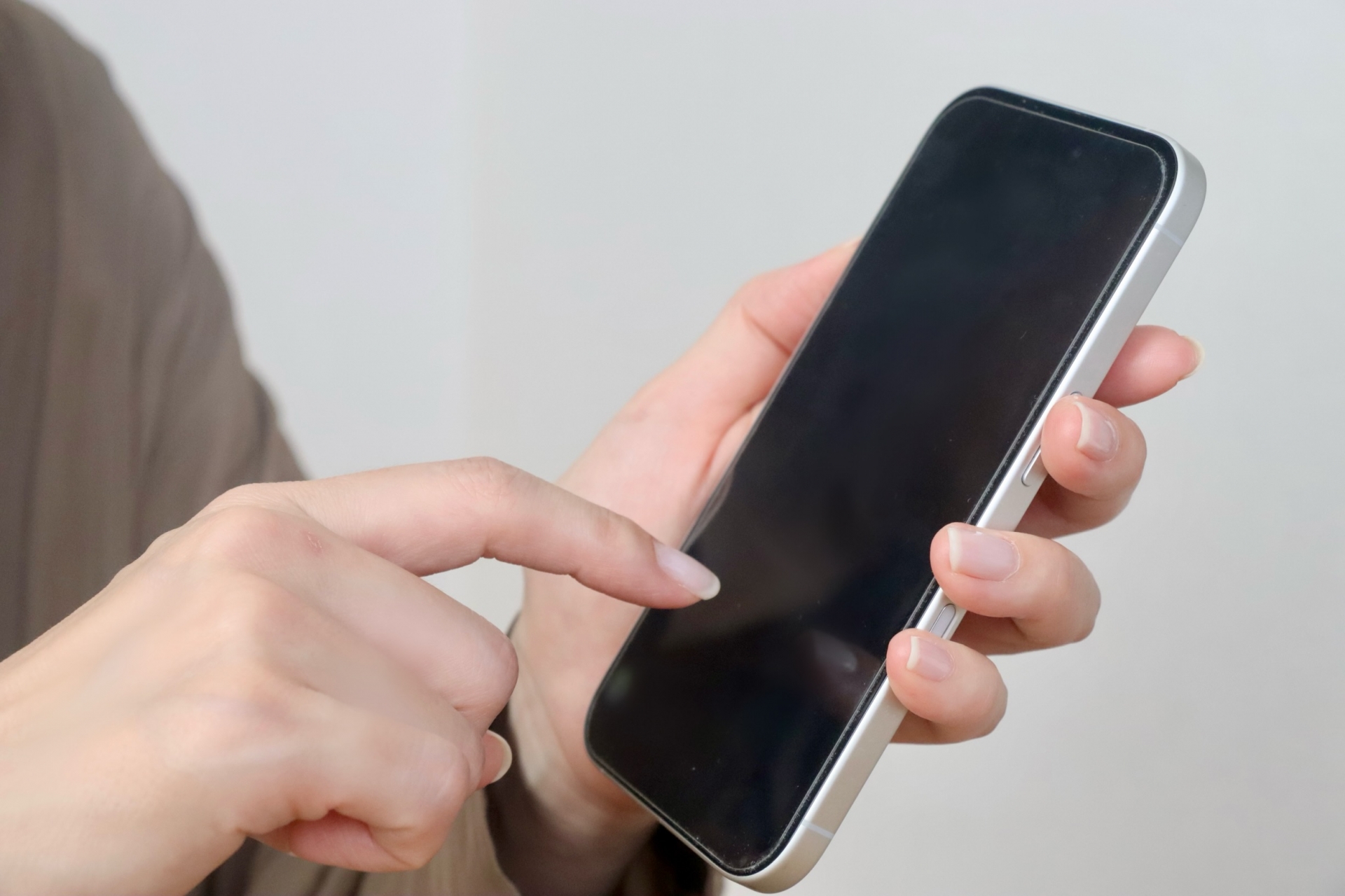 スマホを指さす女性