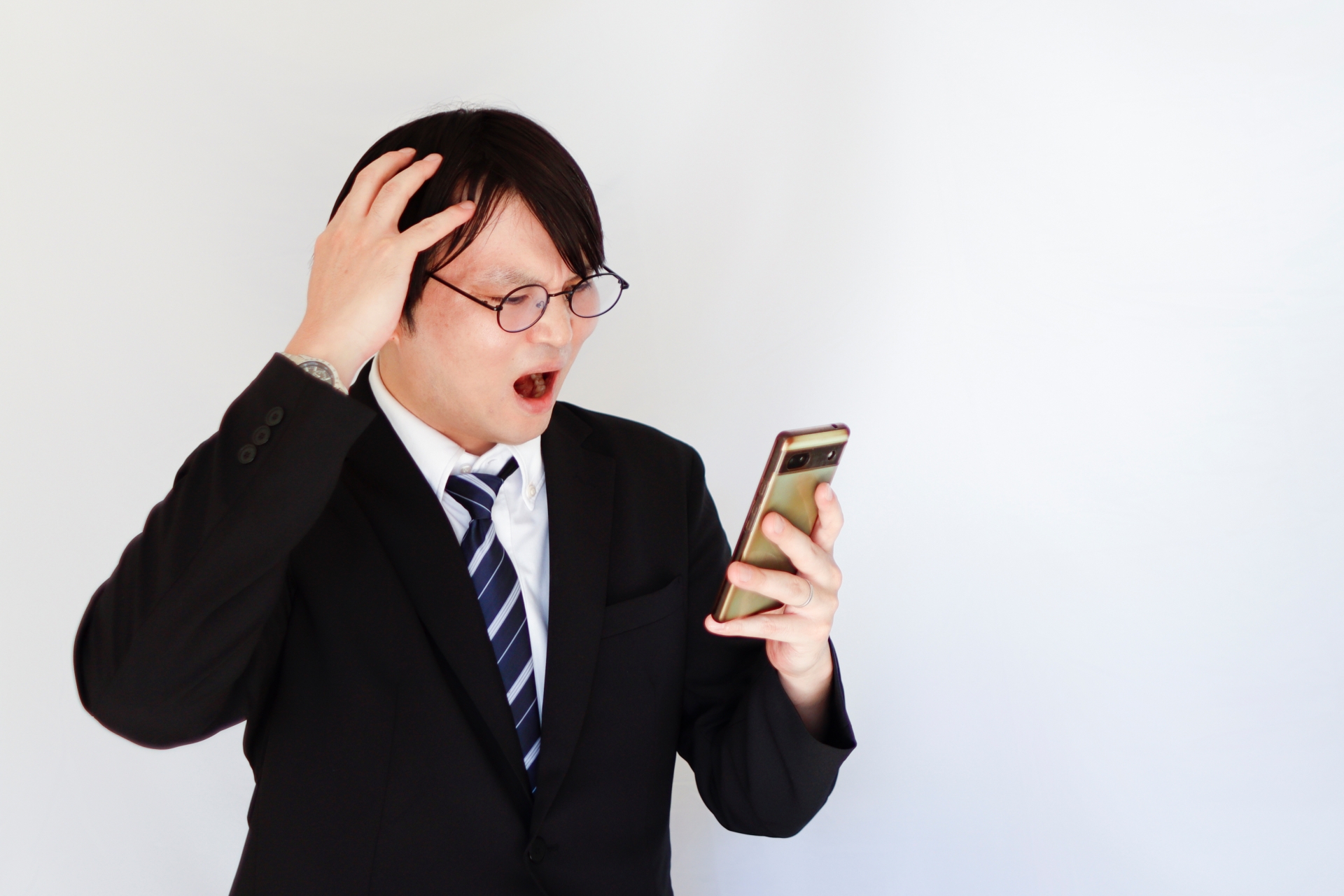 スマホを見て驚く男性