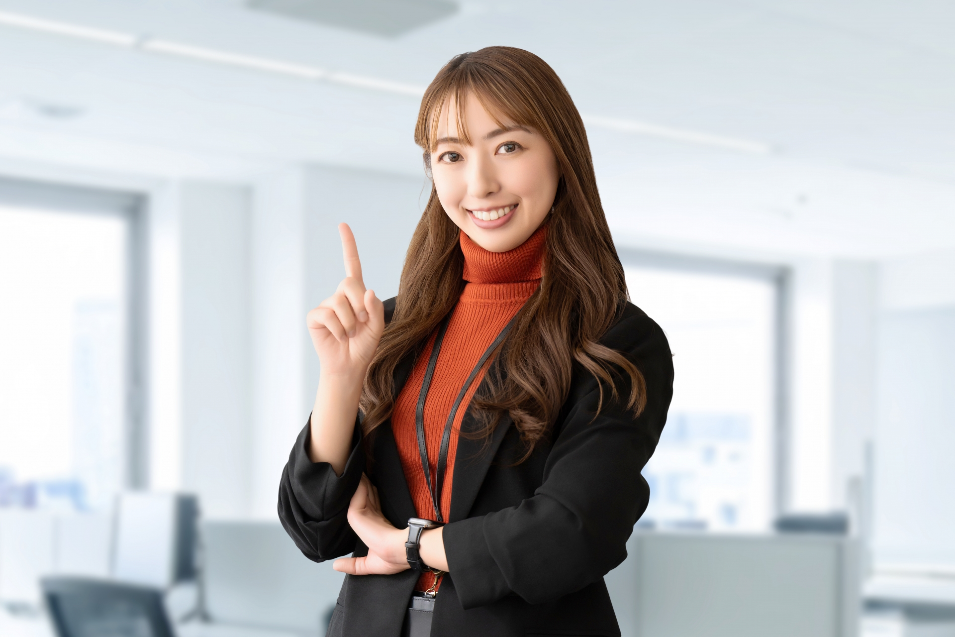 人差し指を立てて案内する笑顔の女性