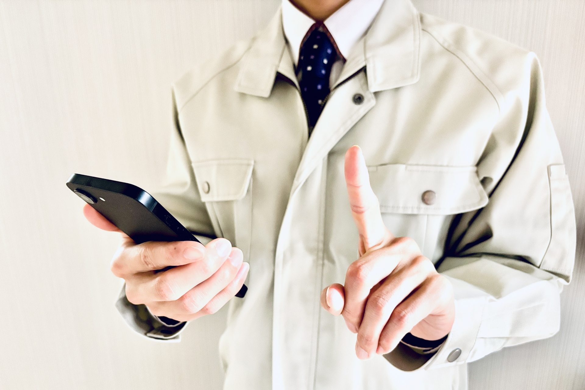 バインダーを持って人差し指を立てる作業員