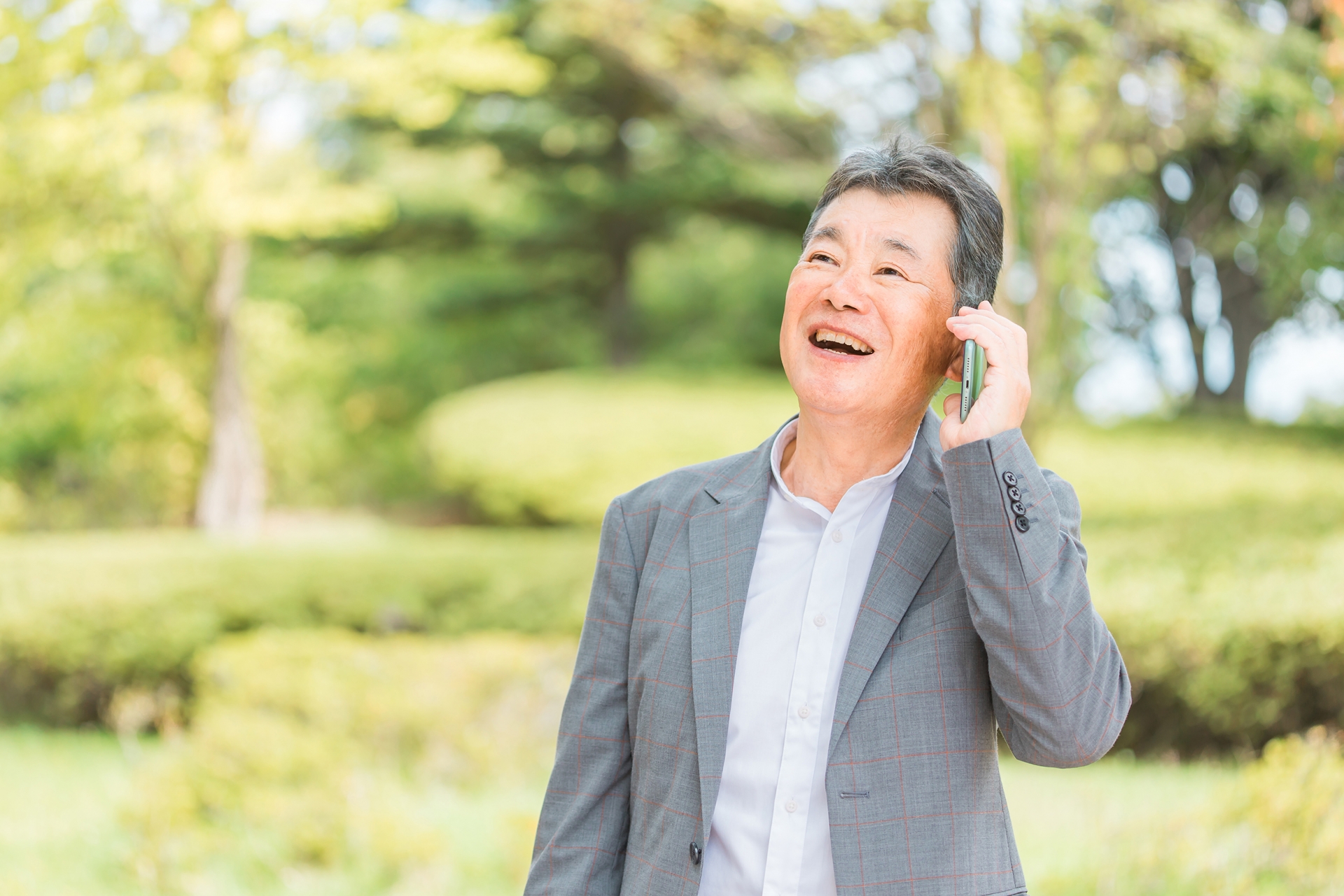 スマホで電話・通話する笑顔の高齢者男性