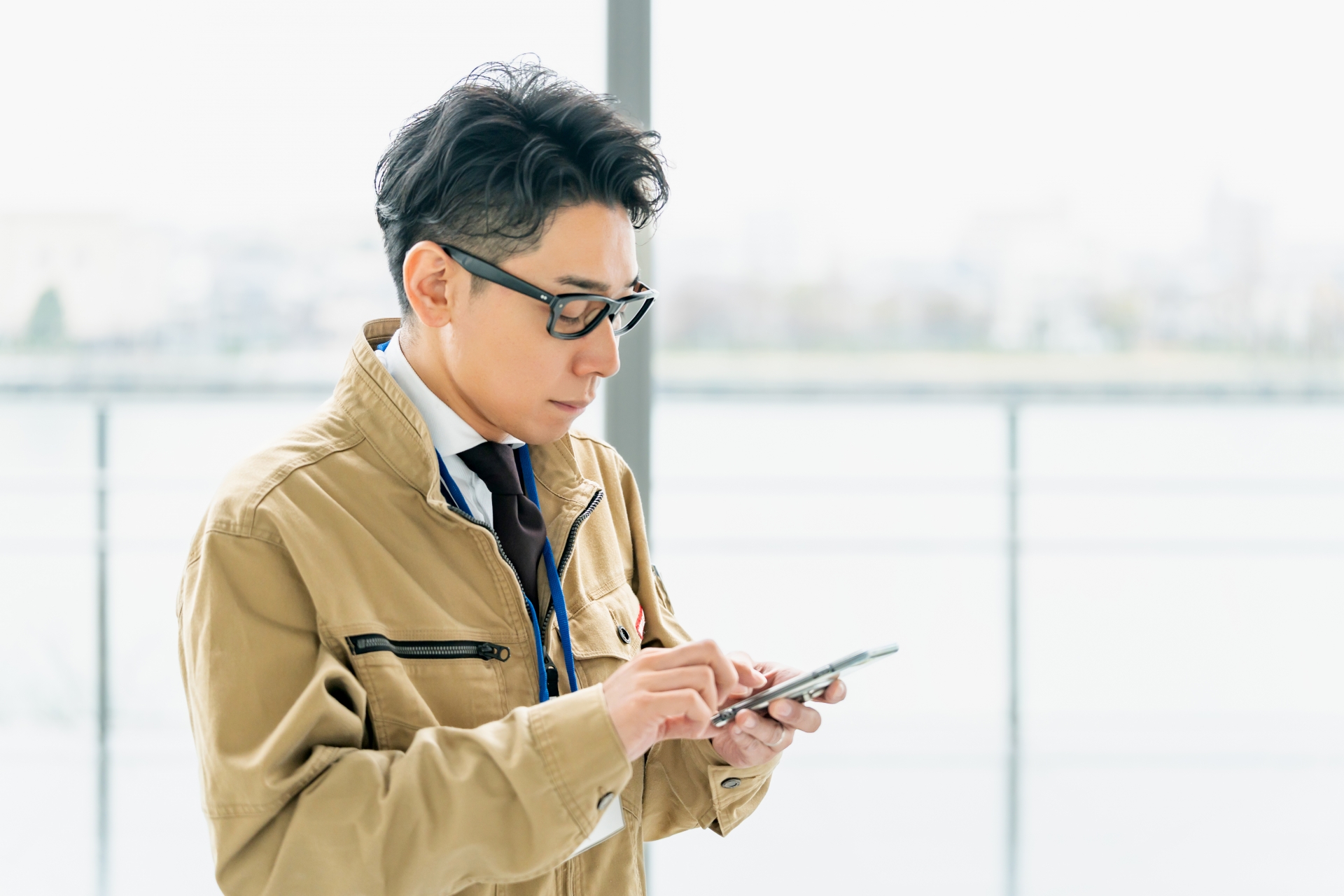 携帯電話を確認する作業服の男性