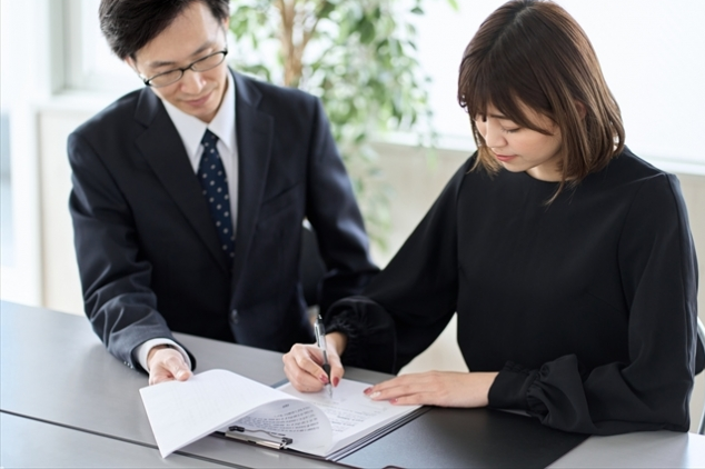 契約書にサインをするアジア人女性