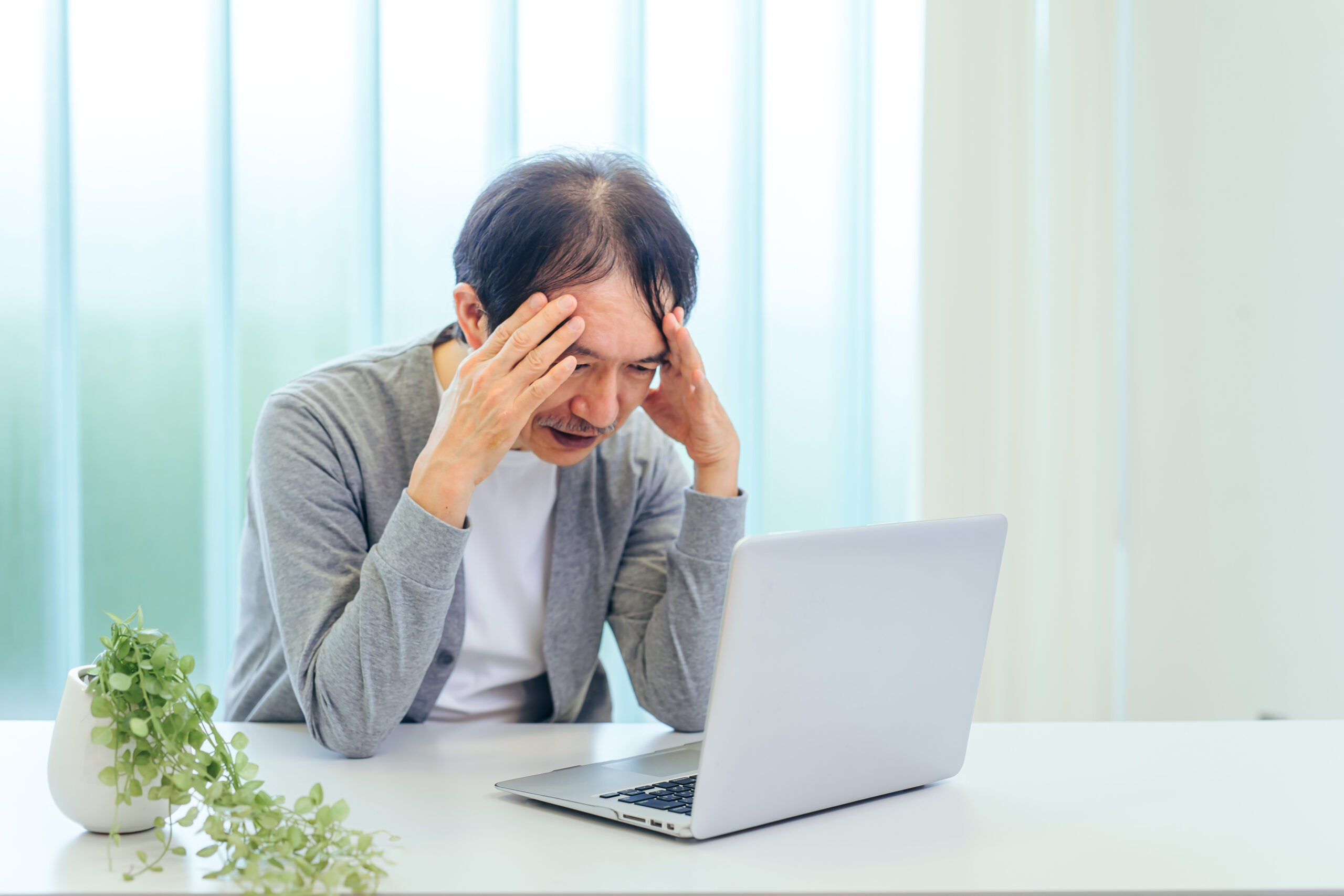 パソコンを使う男性（困る）