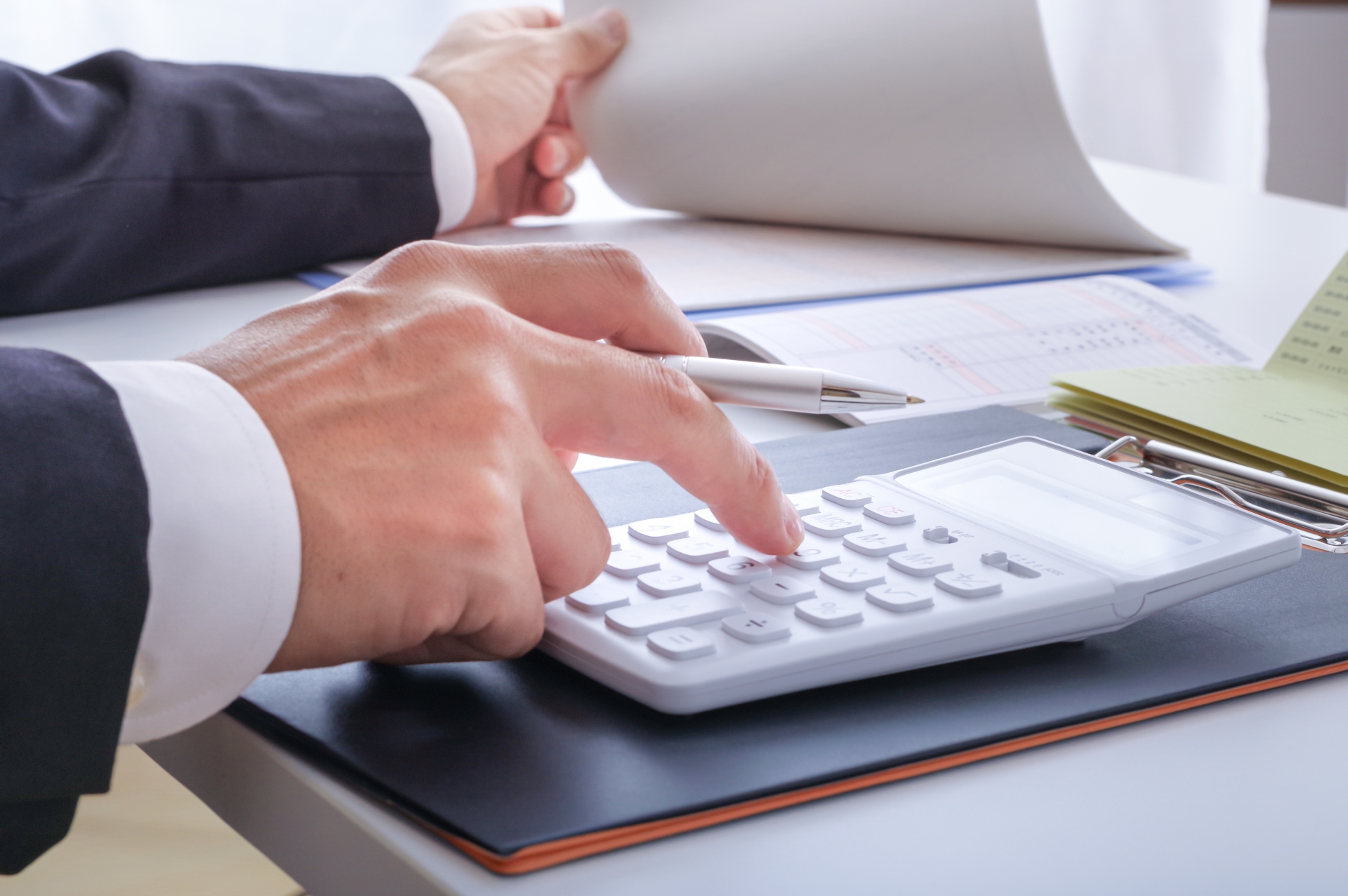 電卓でお金の計算をする人の手元