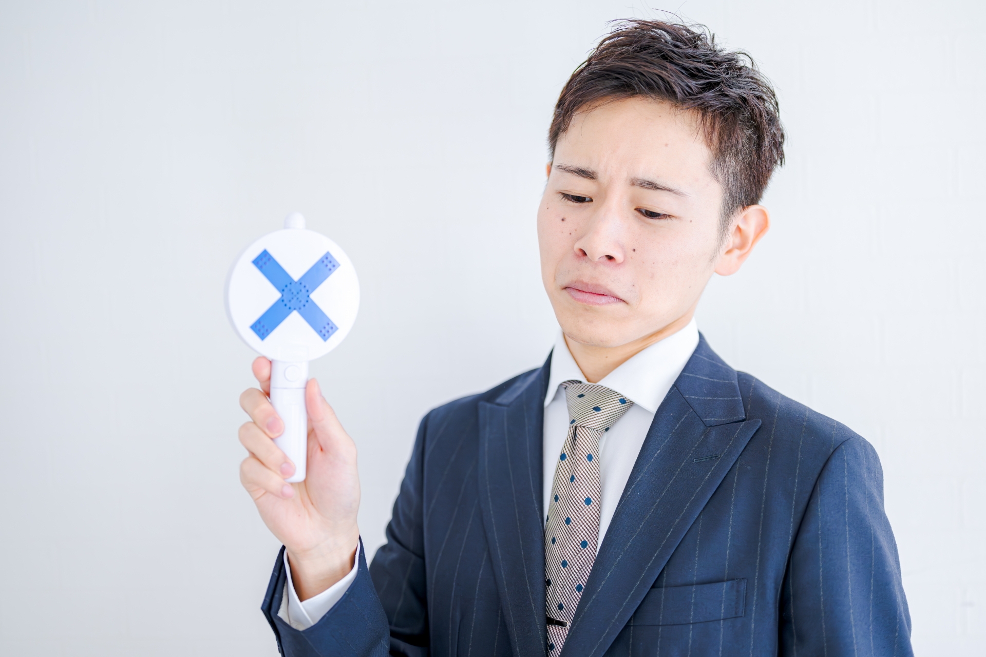 悲しそうに×を出すビジネスマン