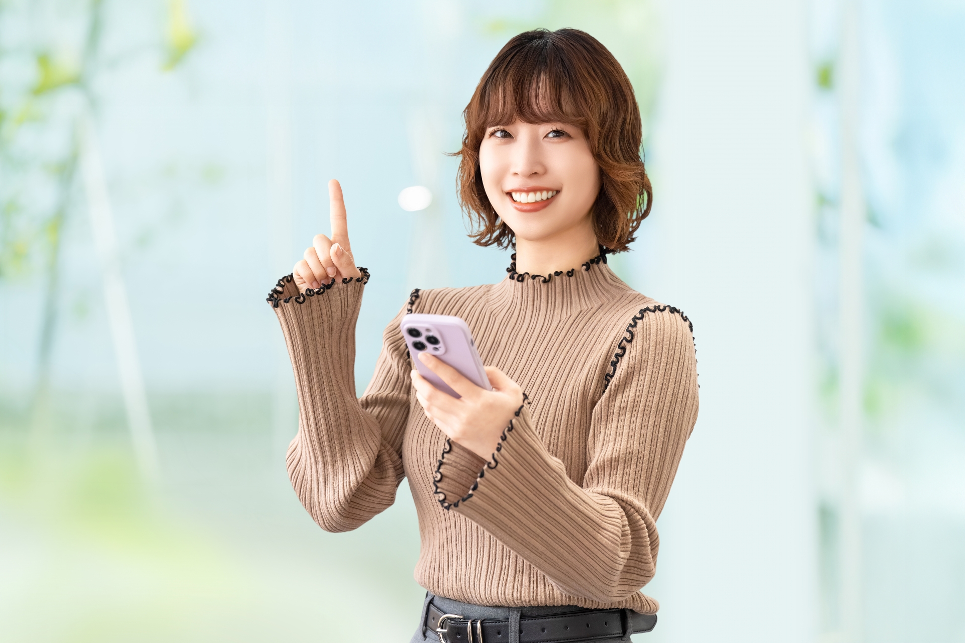 スマホを持って案内をする笑顔の女性