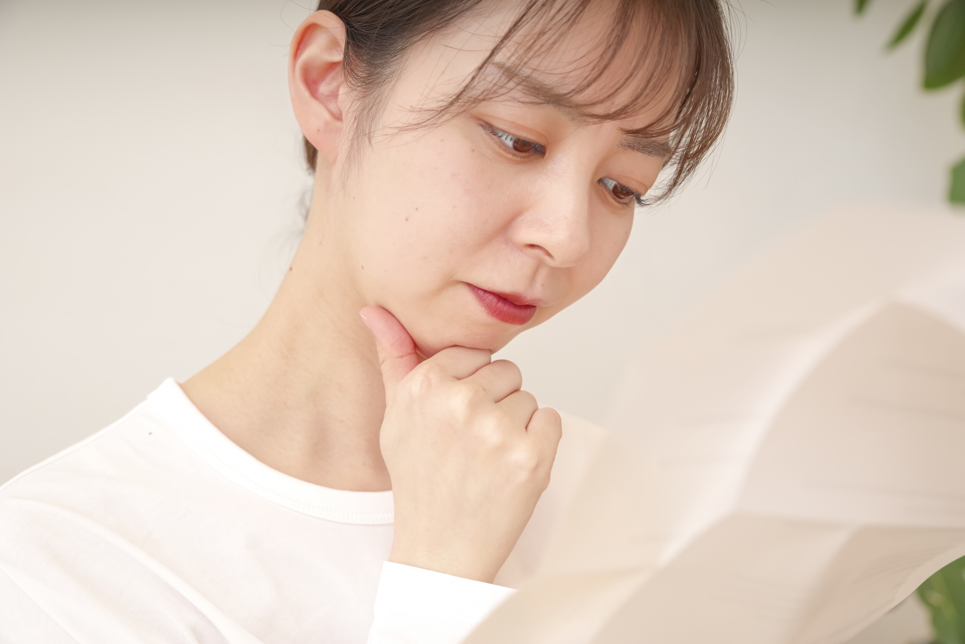 書類を見て複雑な表情をする女性