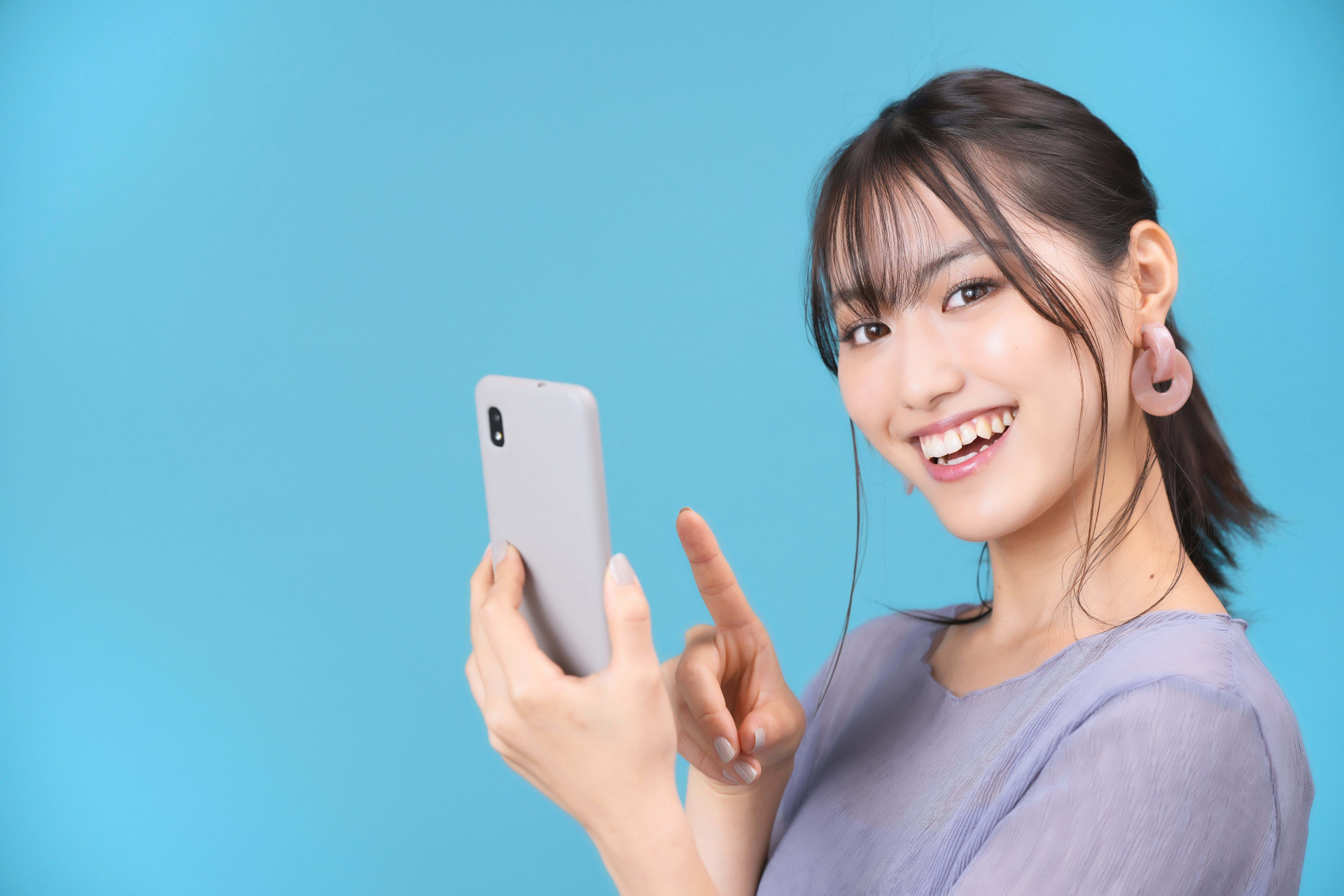 スマホを持つカメラ目線の女性