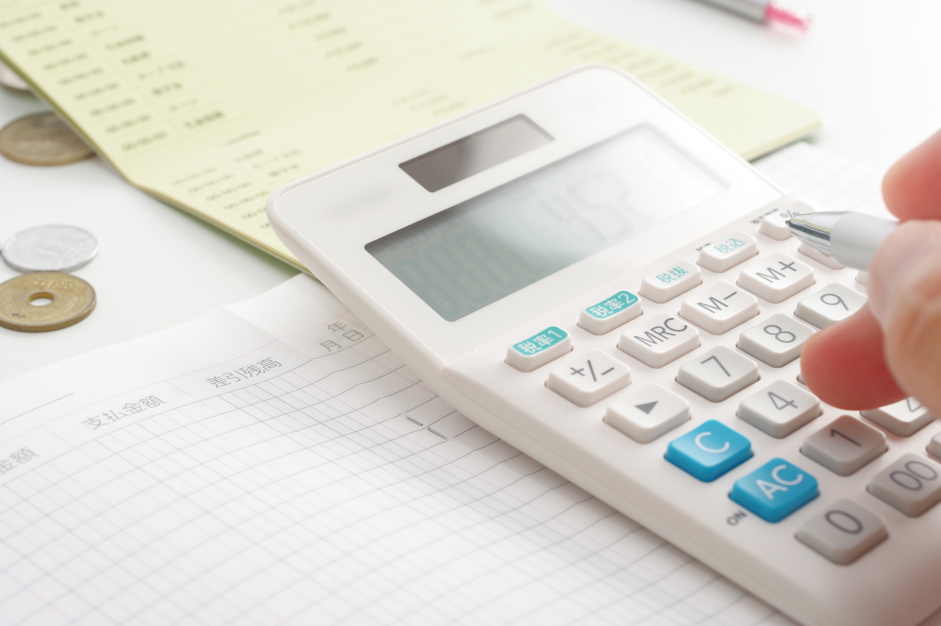 電卓でお金の計算をする人の手元