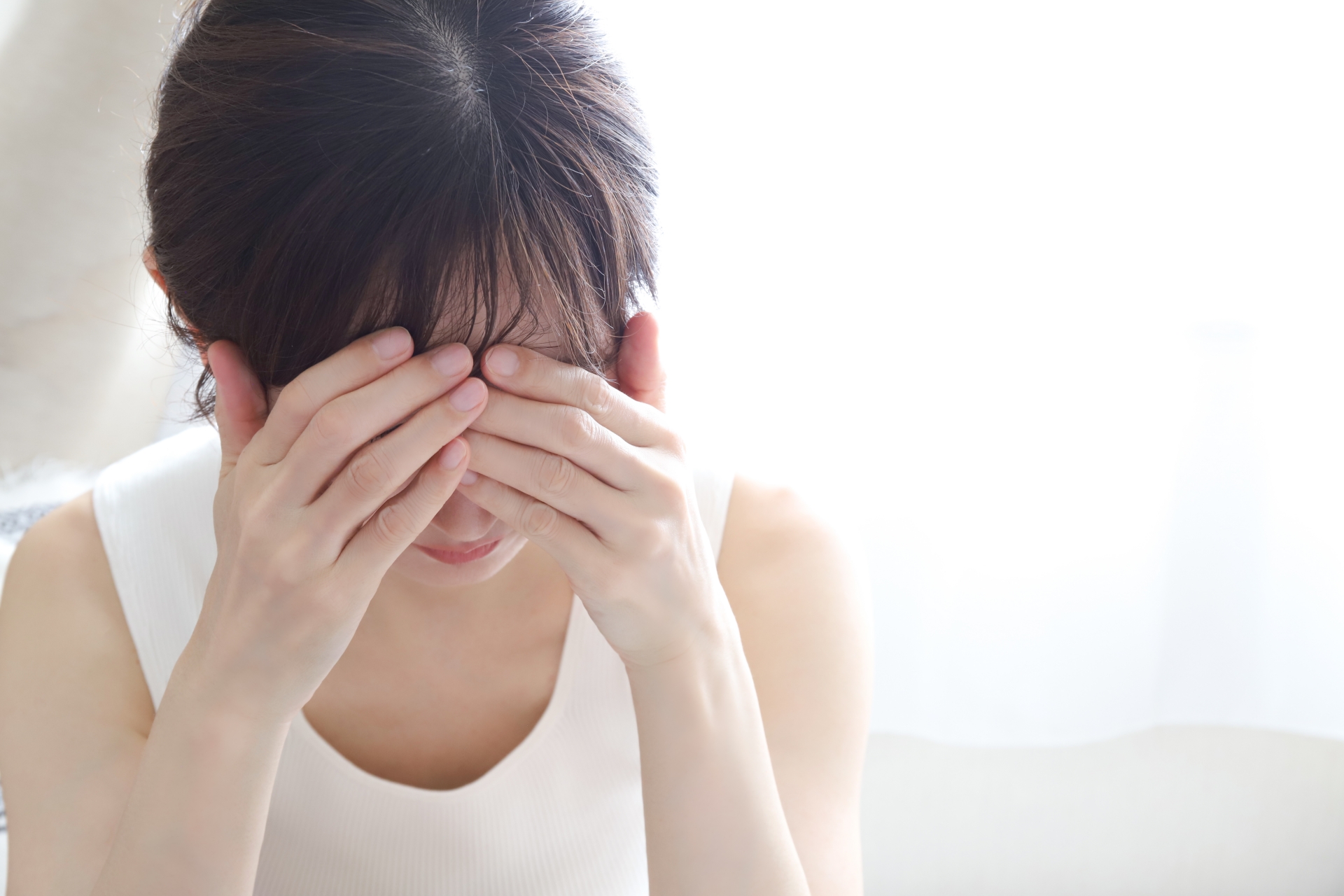 手で顔を覆う女性