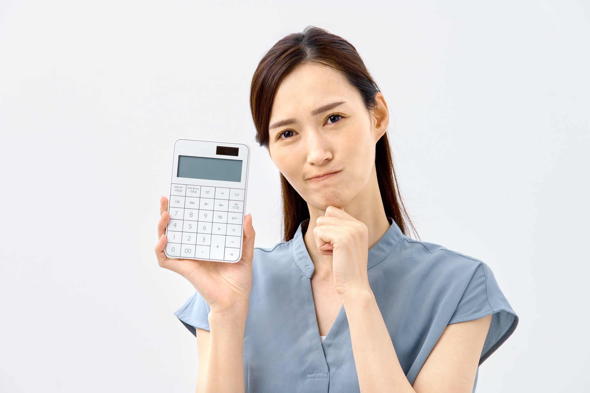 電卓を持って悩む女性