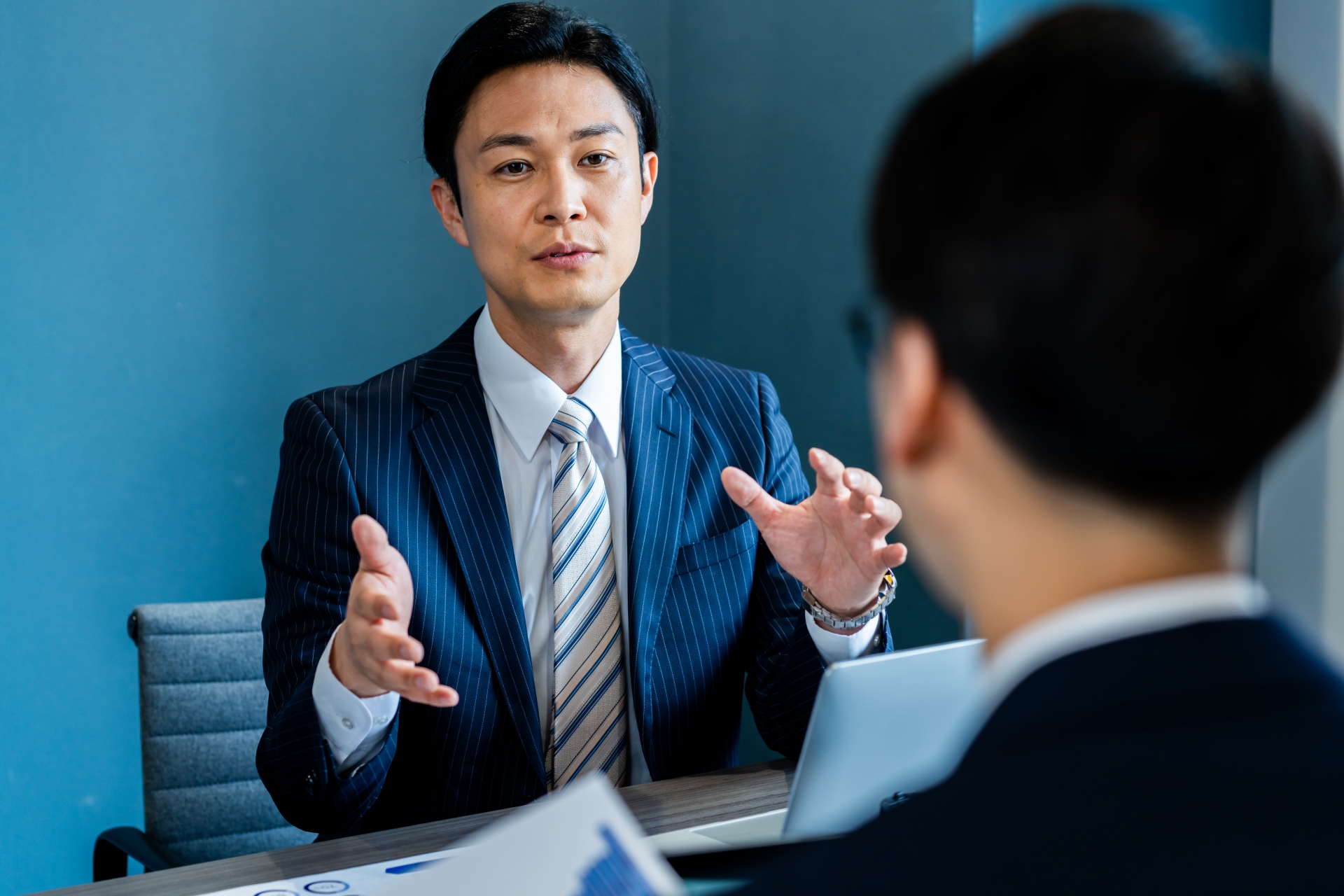 説明をするスーツの男性