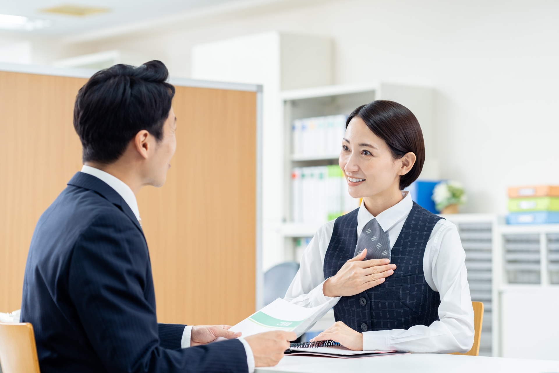 ミドルの男性の接客をするビジネスウーマン