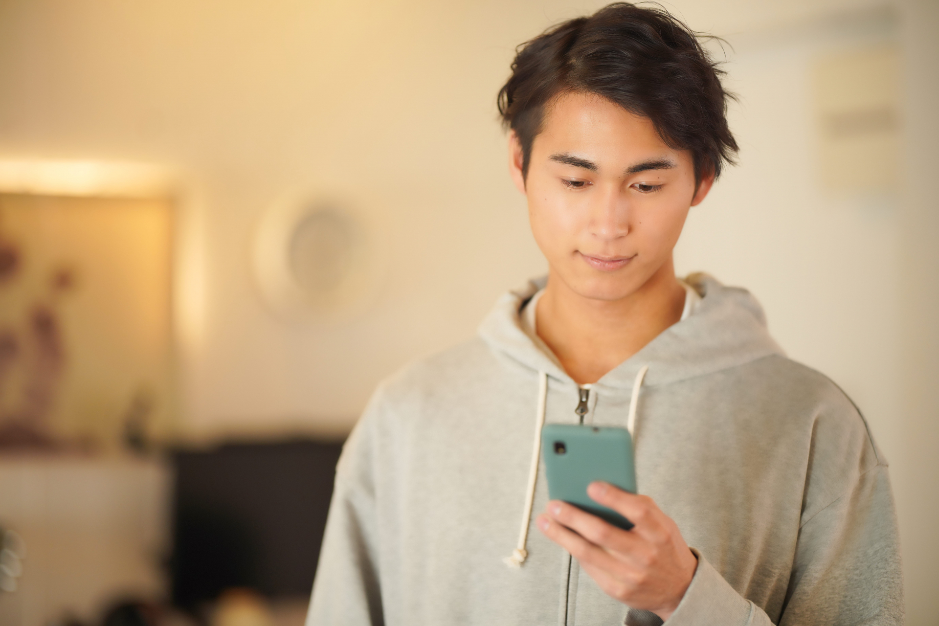 立ってスマホを使う男性2