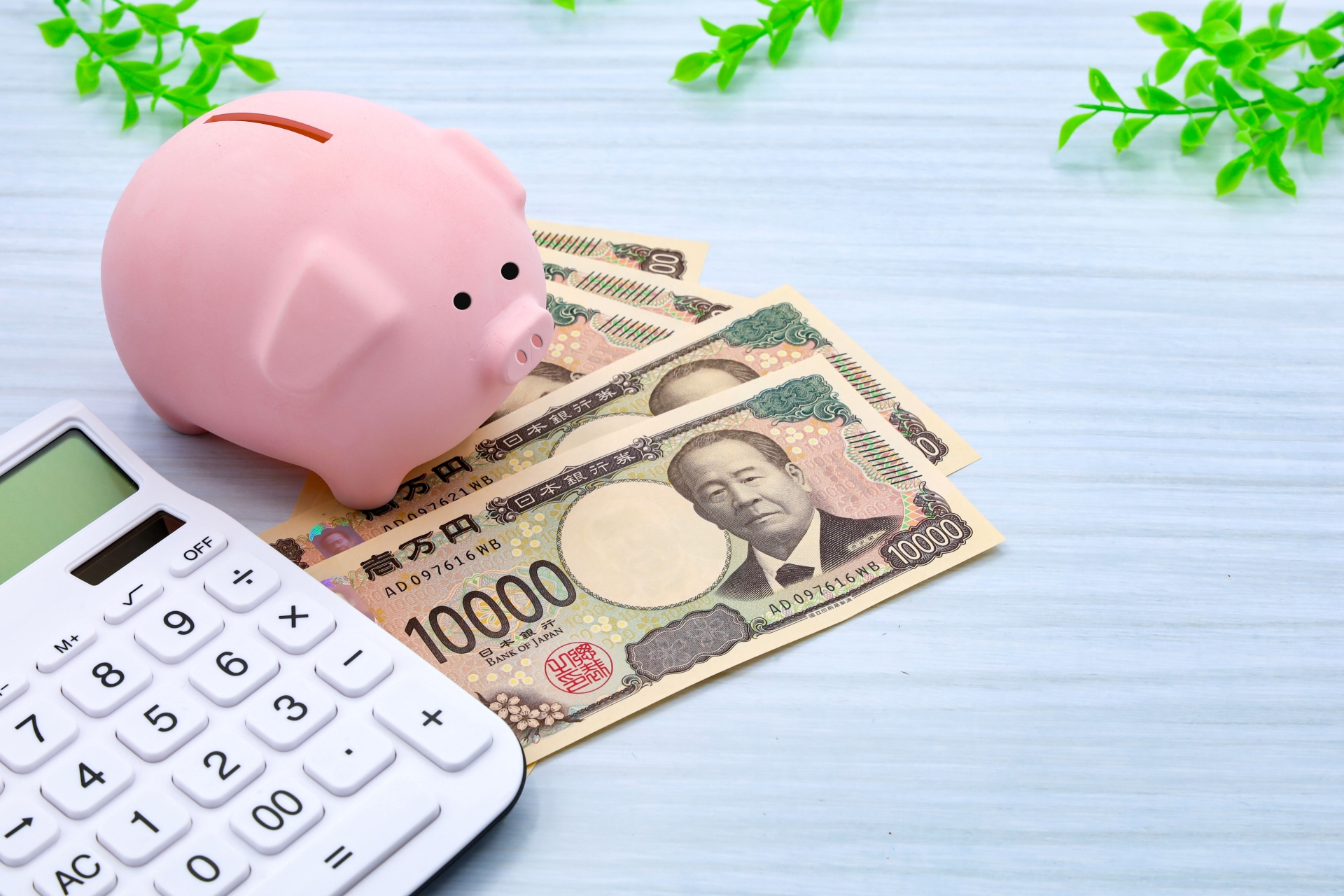 豚の貯金箱と現金と電卓