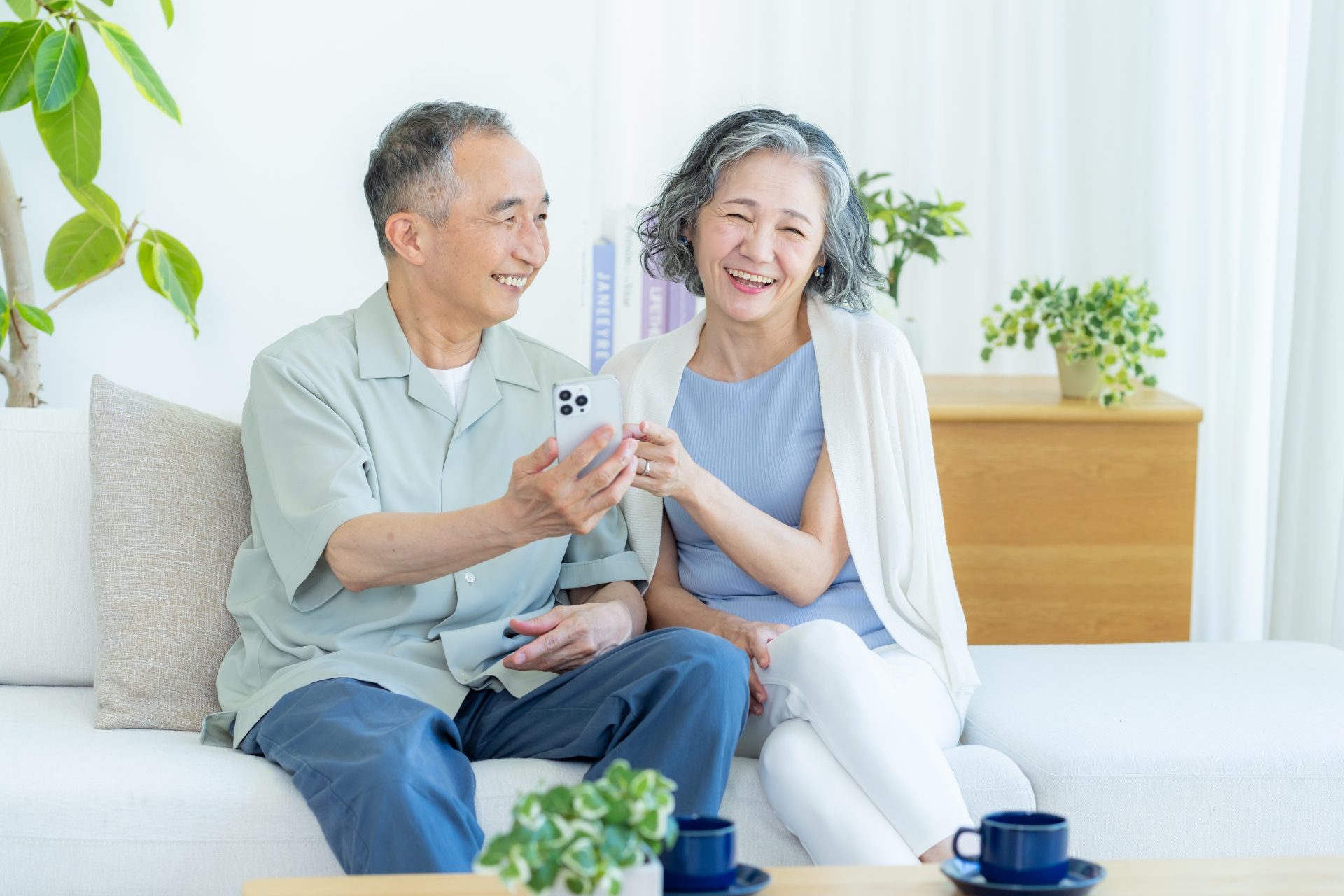 リビングでスマホを見るシニア夫婦
