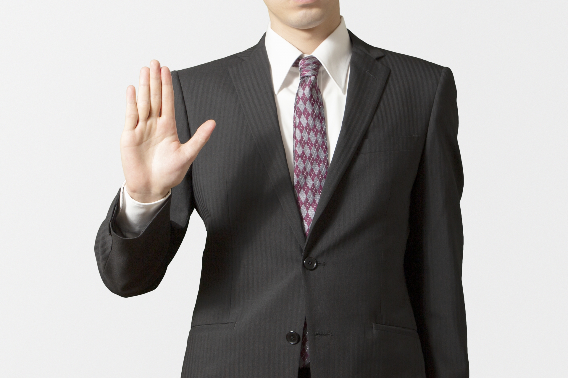 右手の手のひらを見せるビジネスマン