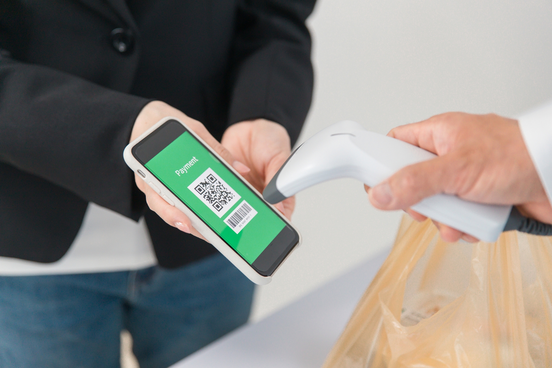 スマホを使って二次元コード決済する女性