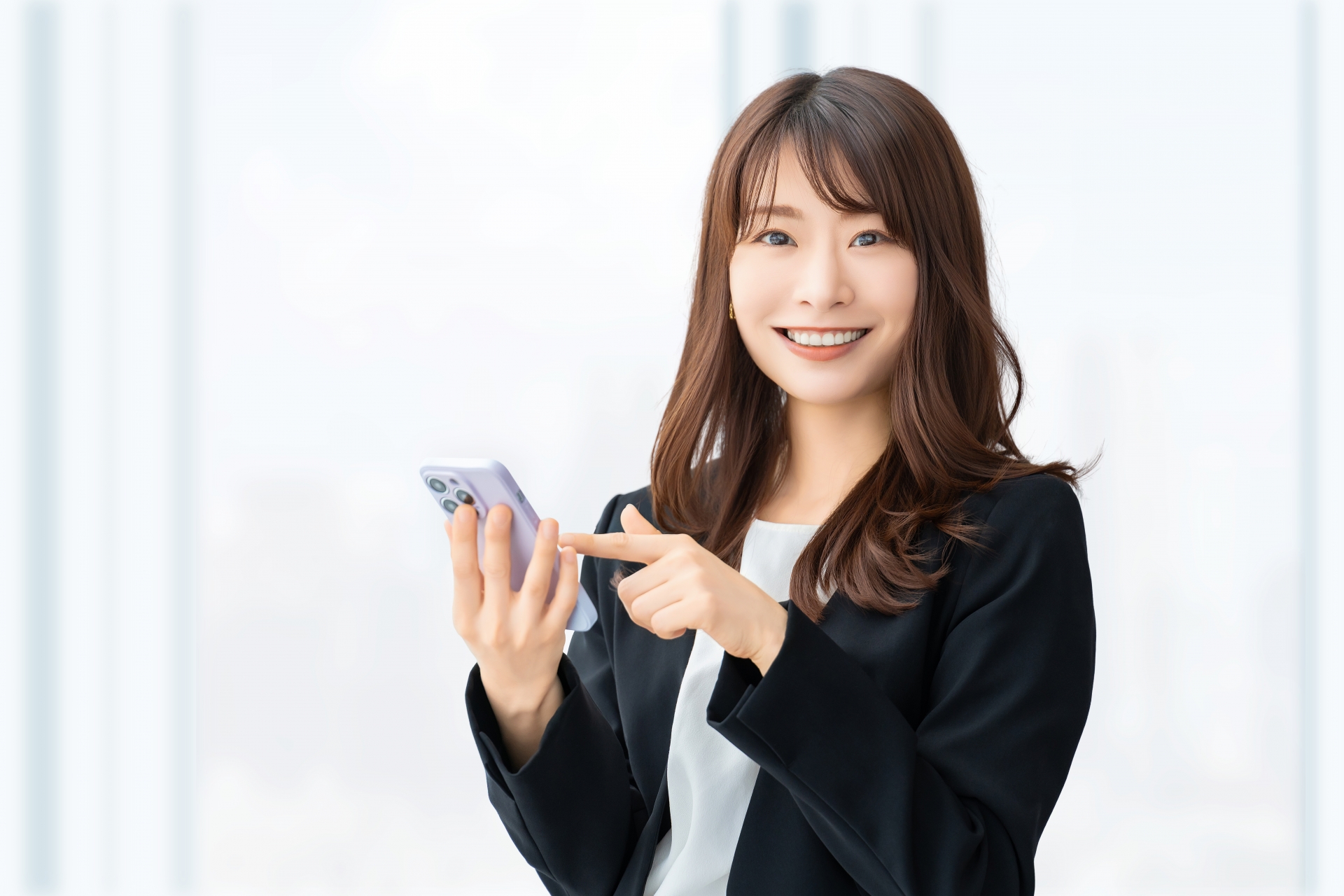 スマホを持つ笑顔の女性・ビジネスウーマン