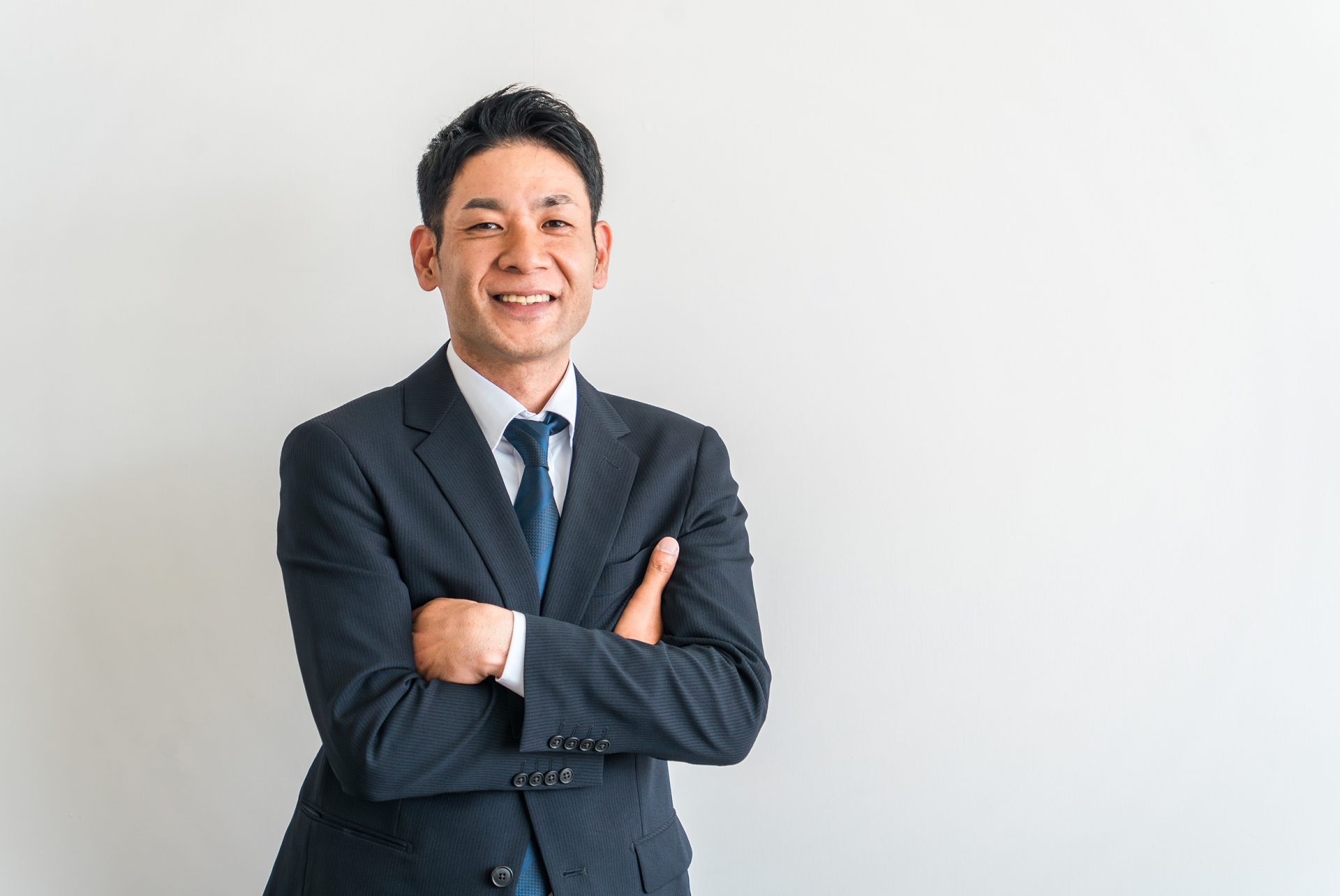 腕組みするスーツ姿のアジア人ビジネスマン