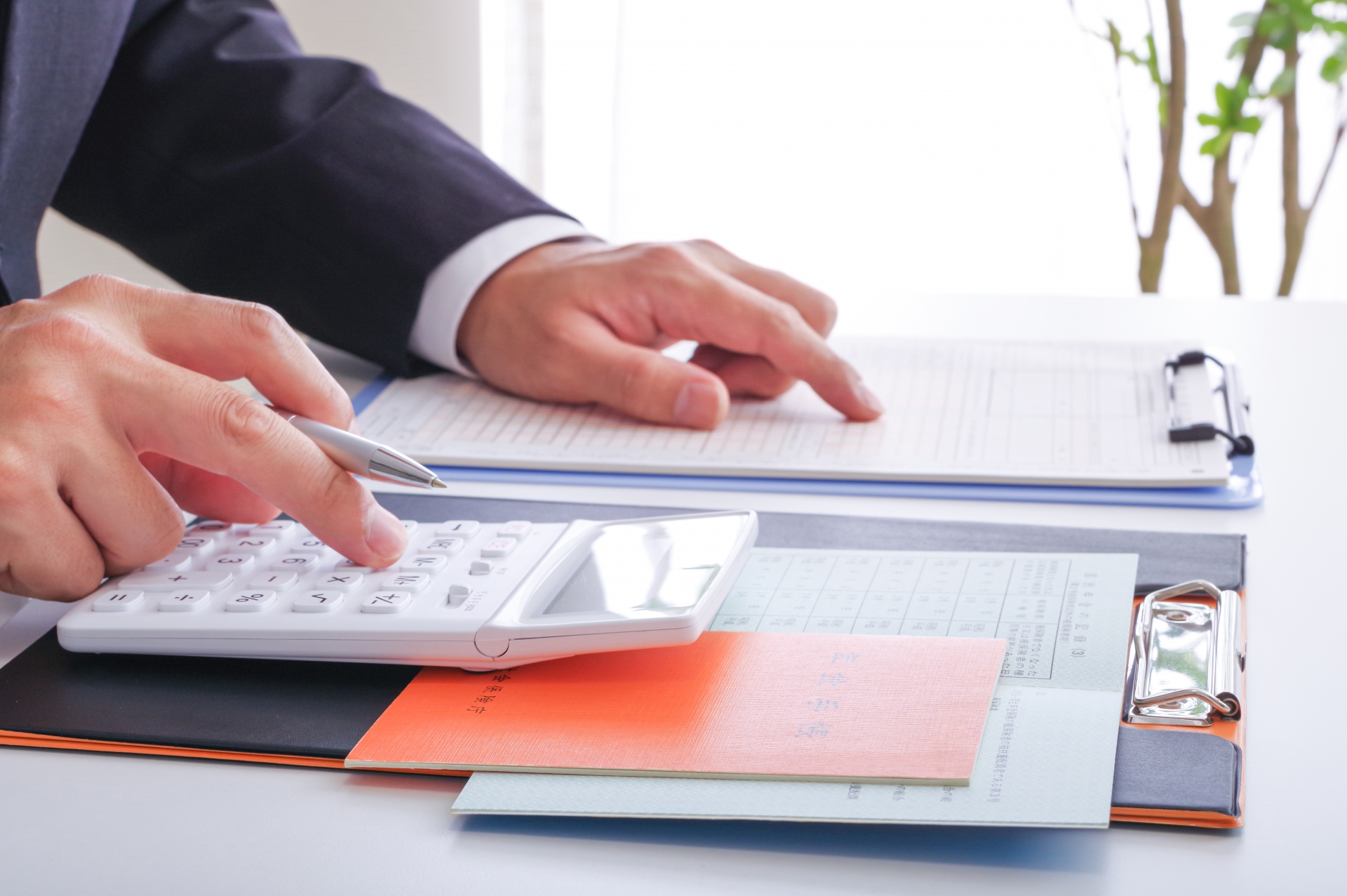 年金の受給額を計算するスーツ姿の男性