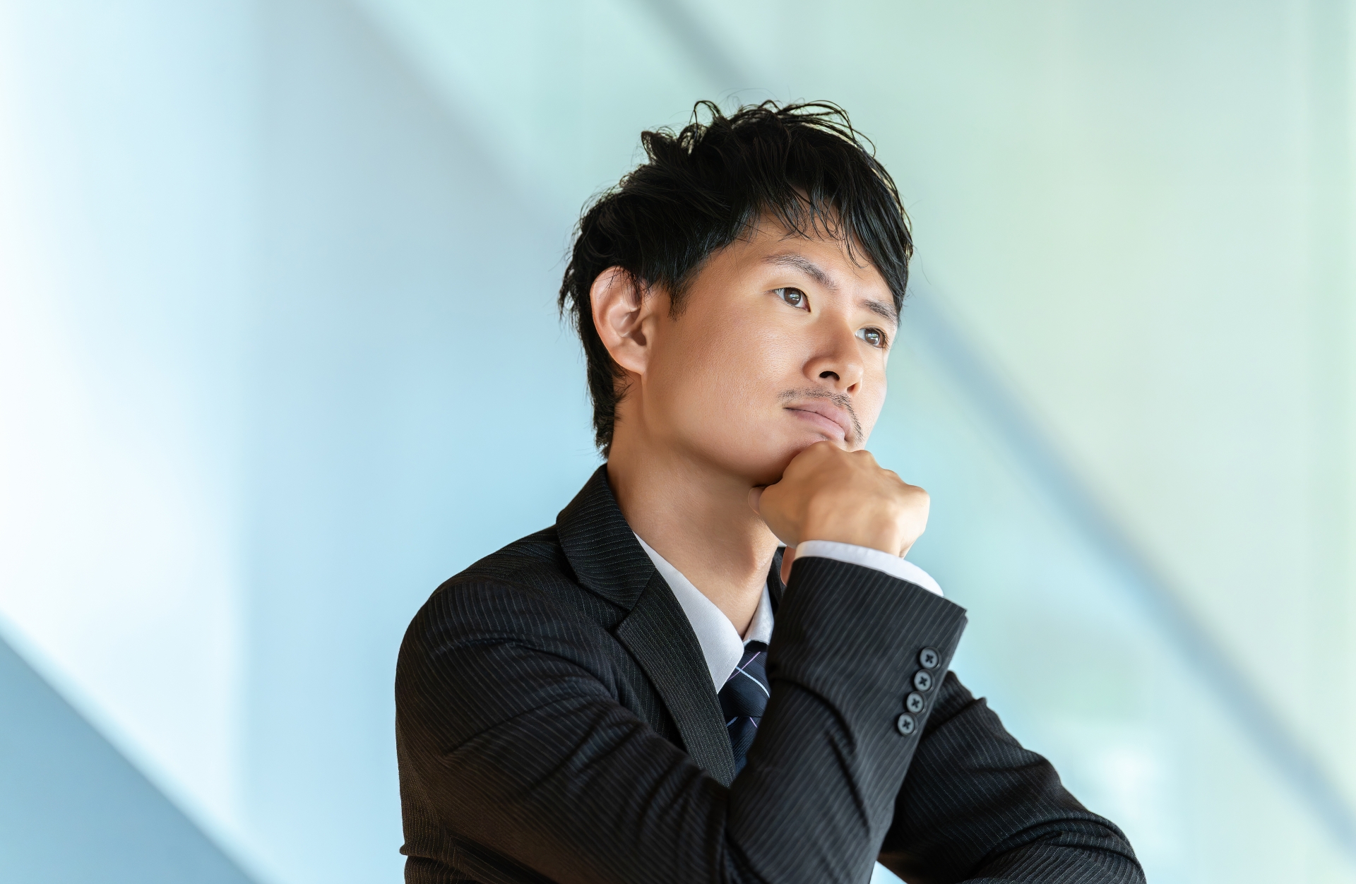 考えごとをする男性ビジネスマン
