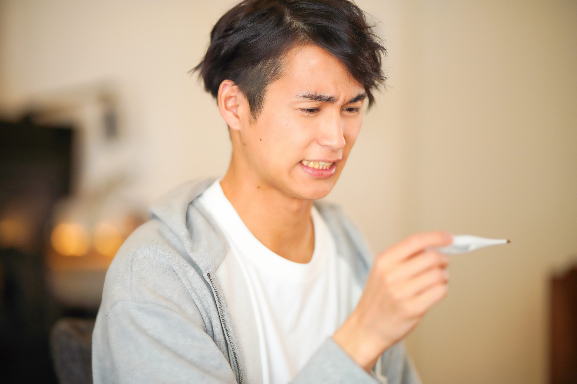 熱を測った体温計を見る男性2