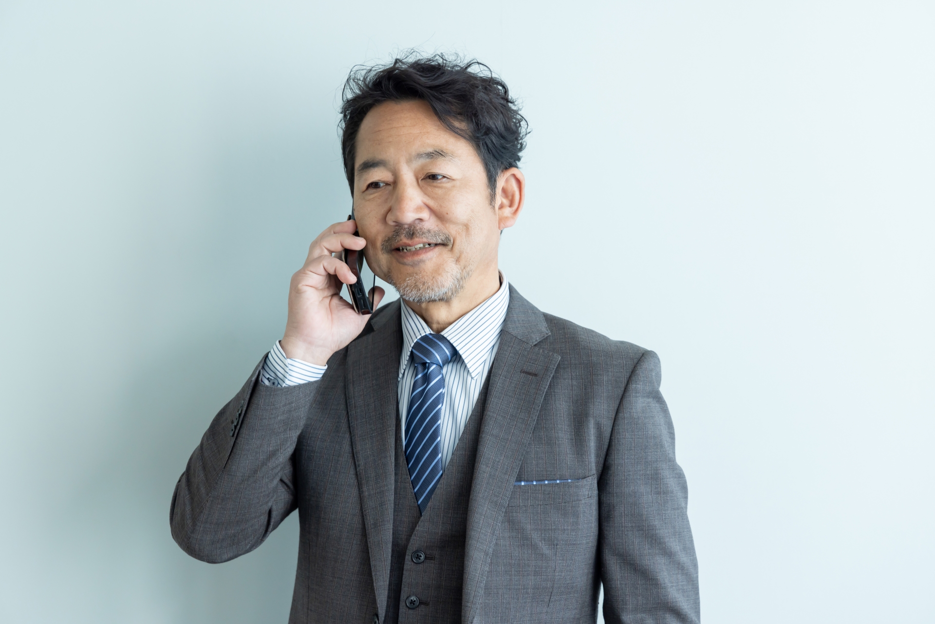 スマートフォンで話すビジネスパーソン