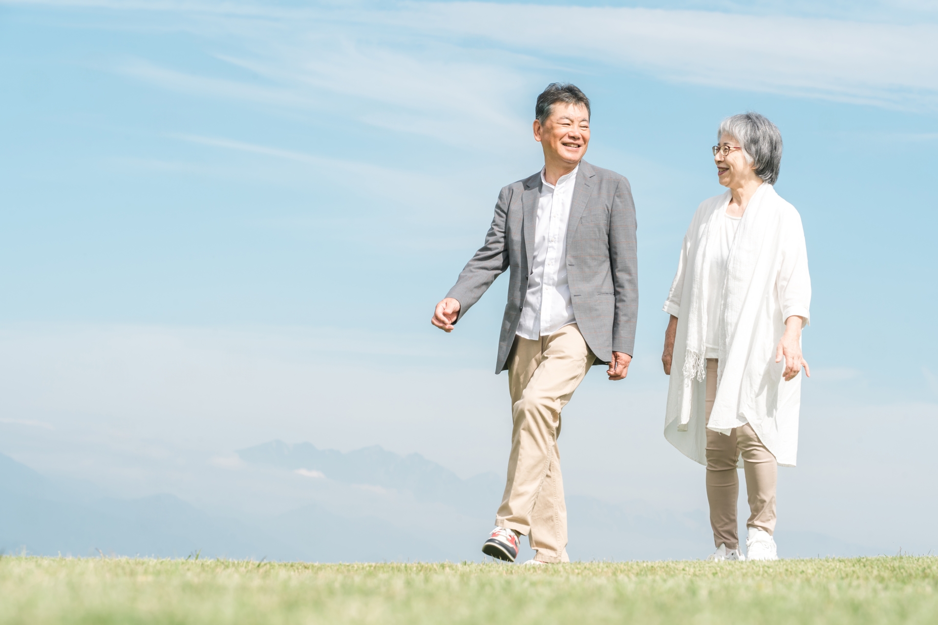 公園・旅行先を話しながら歩く高齢者夫婦