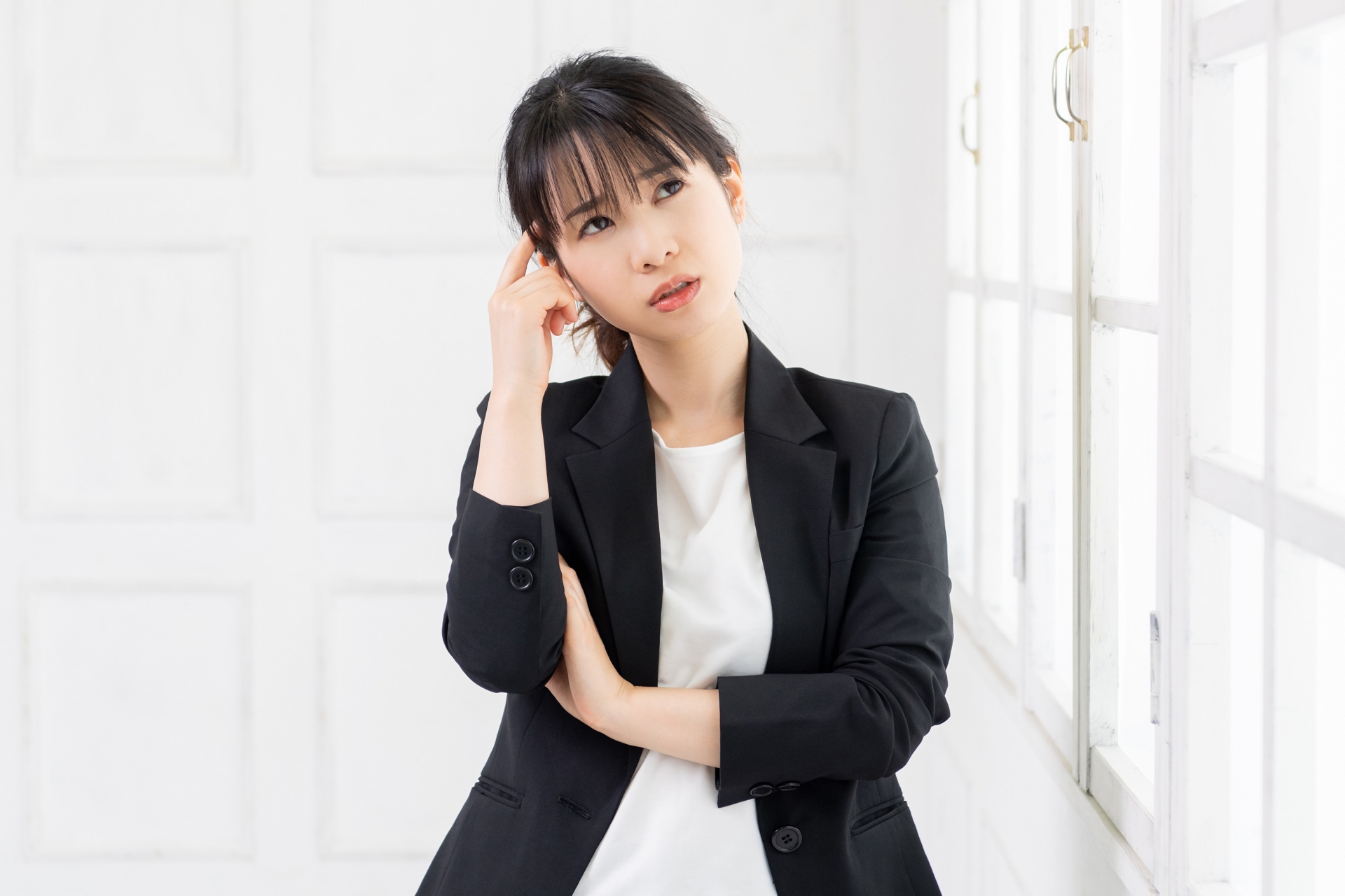 考えるジェスチャーをする若い女性