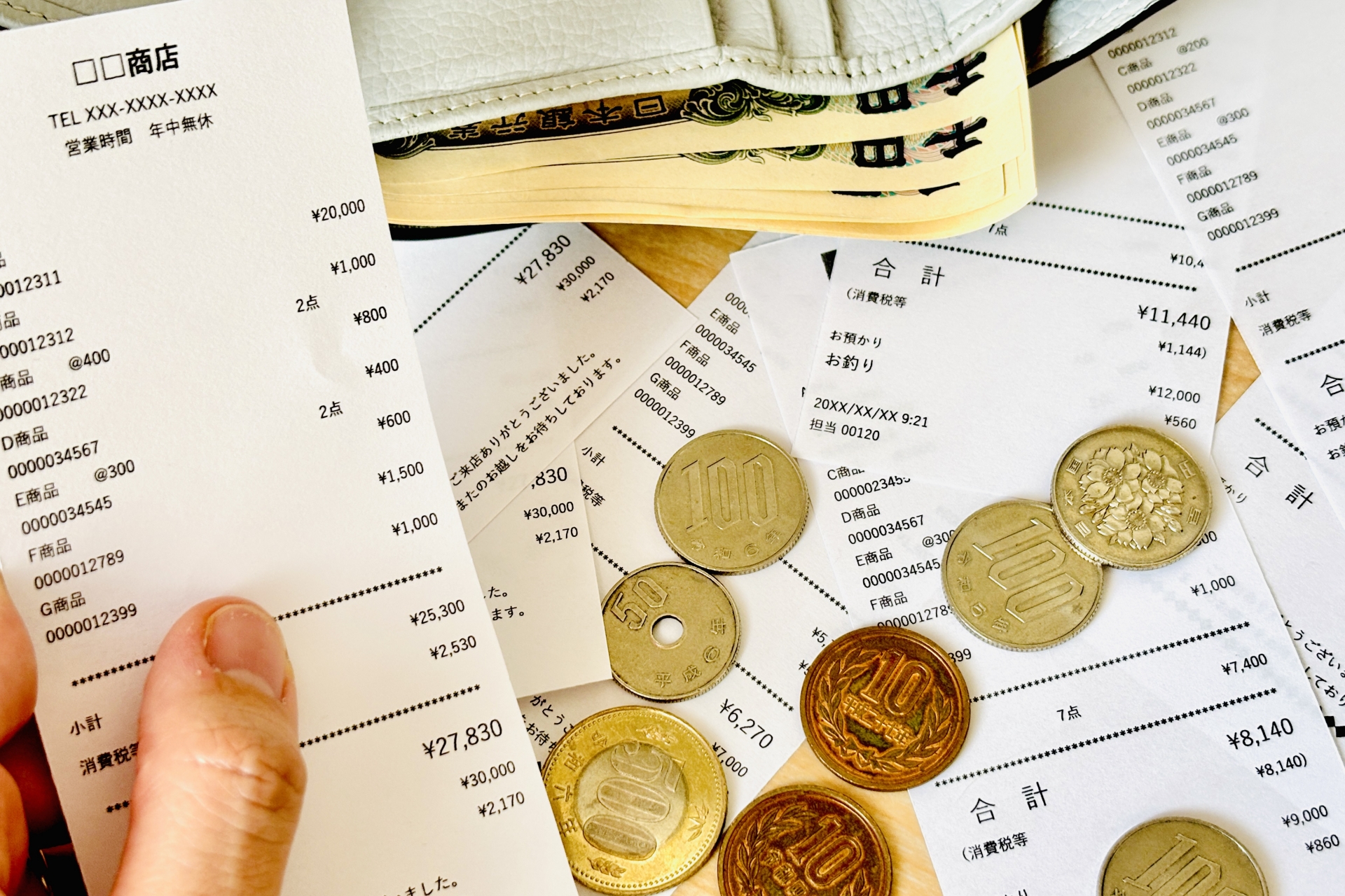 家計管理する人の手とレシート