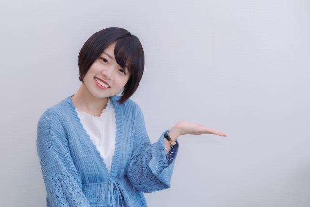 左手で案内する女性