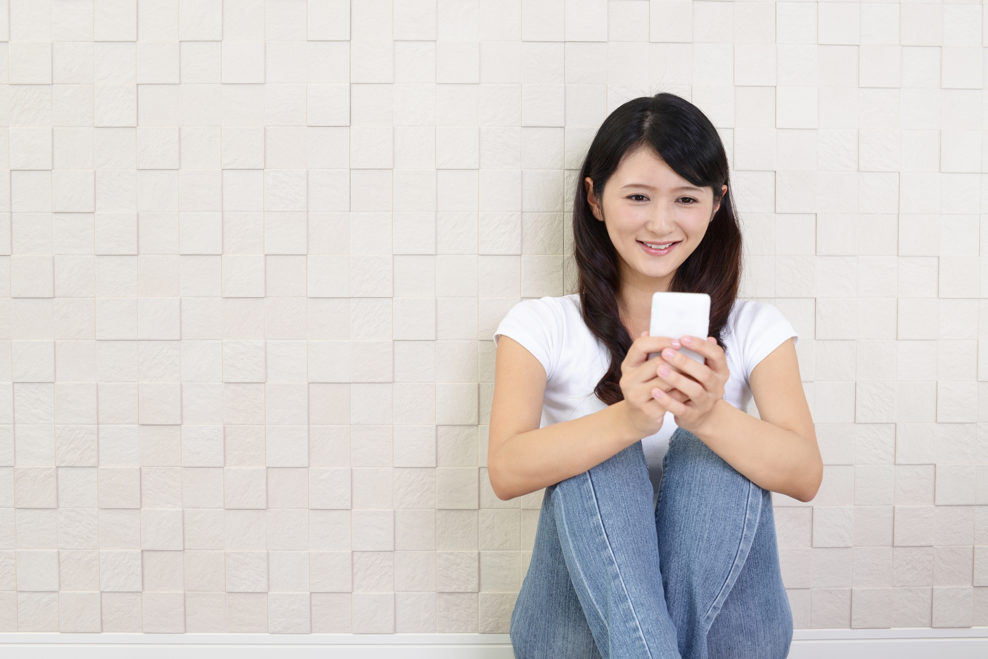 スマートフォンを持つ笑顔の女性