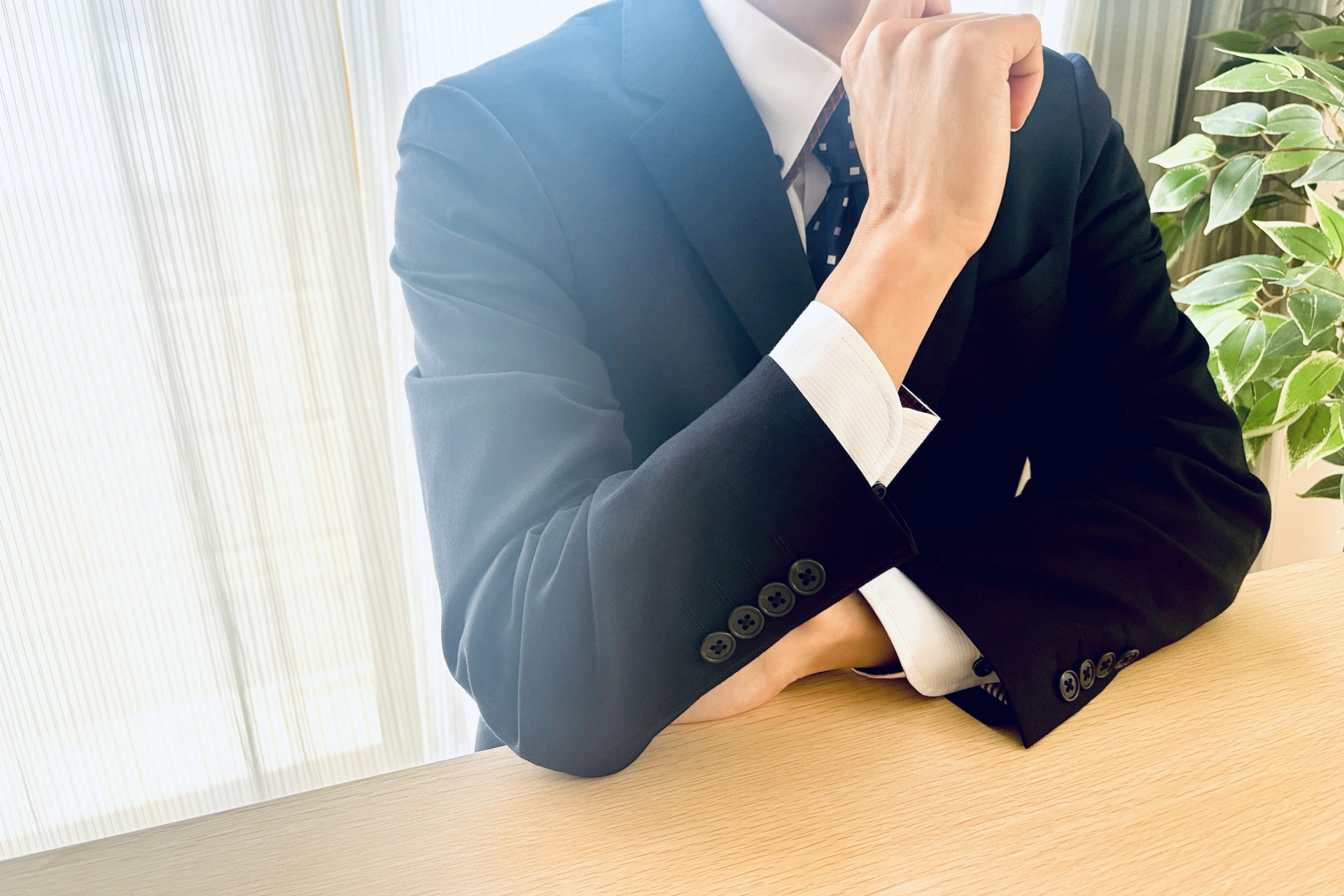 肘をつくスーツの男性