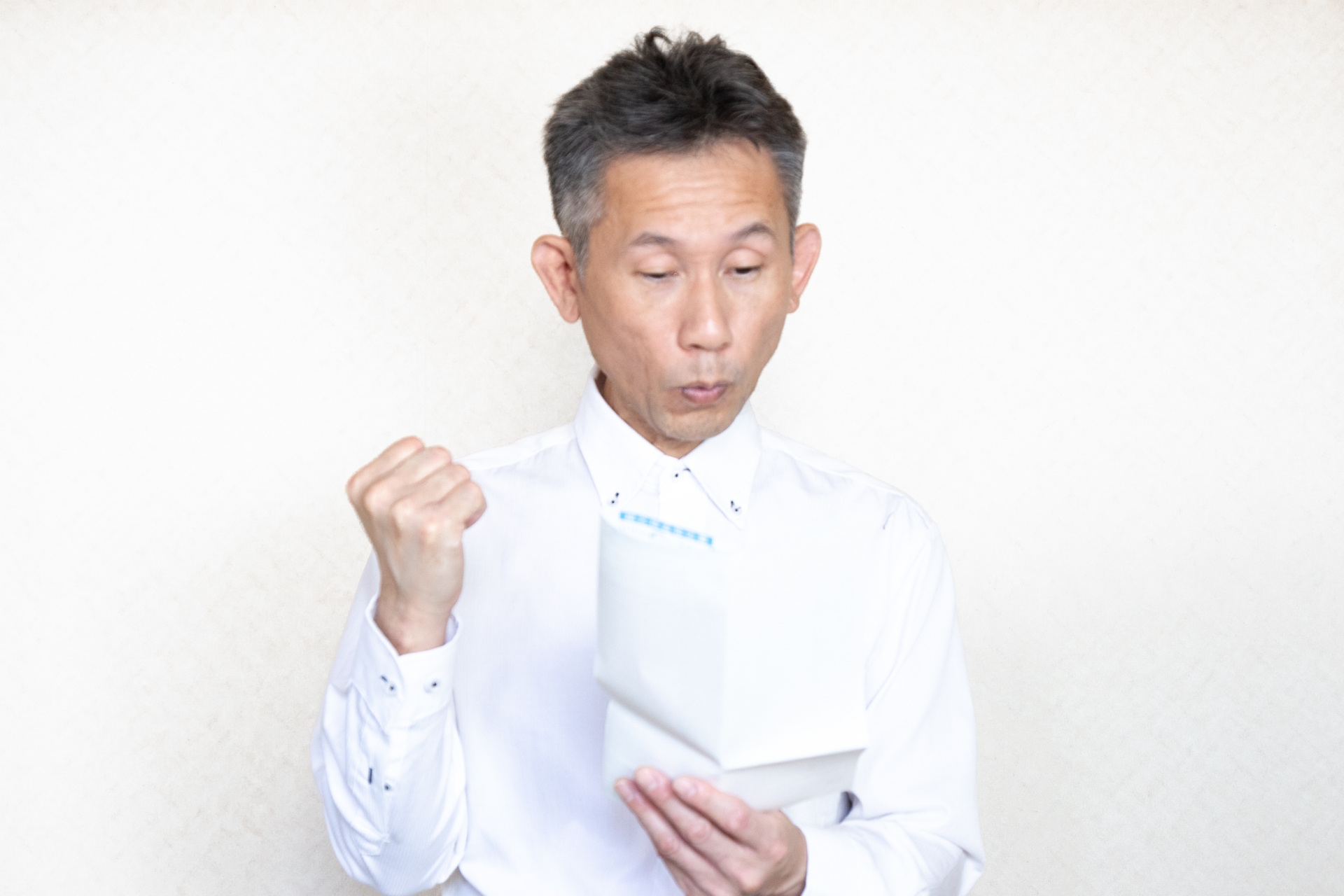 書類を見て喜ぶ中高年男性