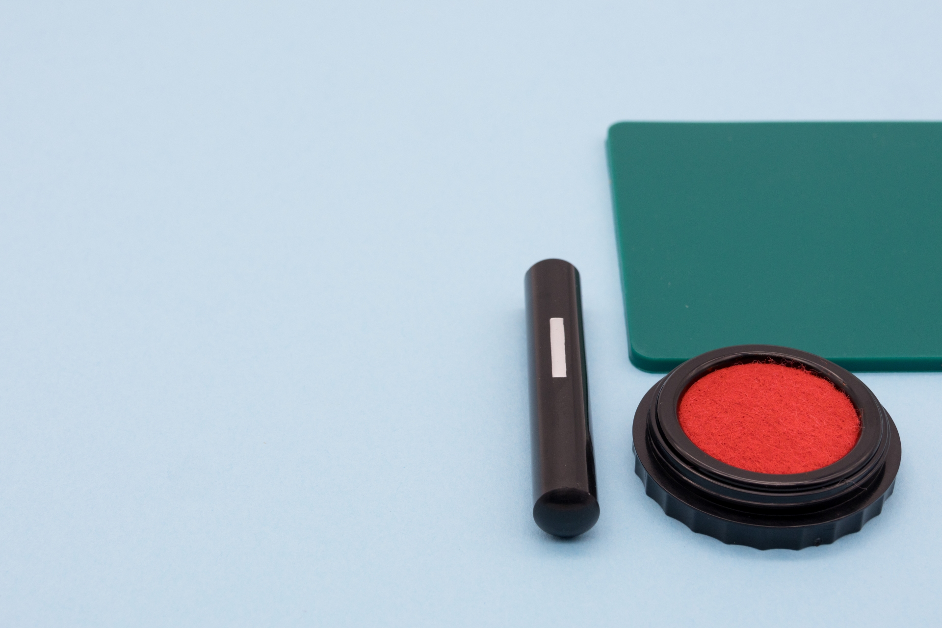 水色の背景に印鑑、朱肉、捺印マット