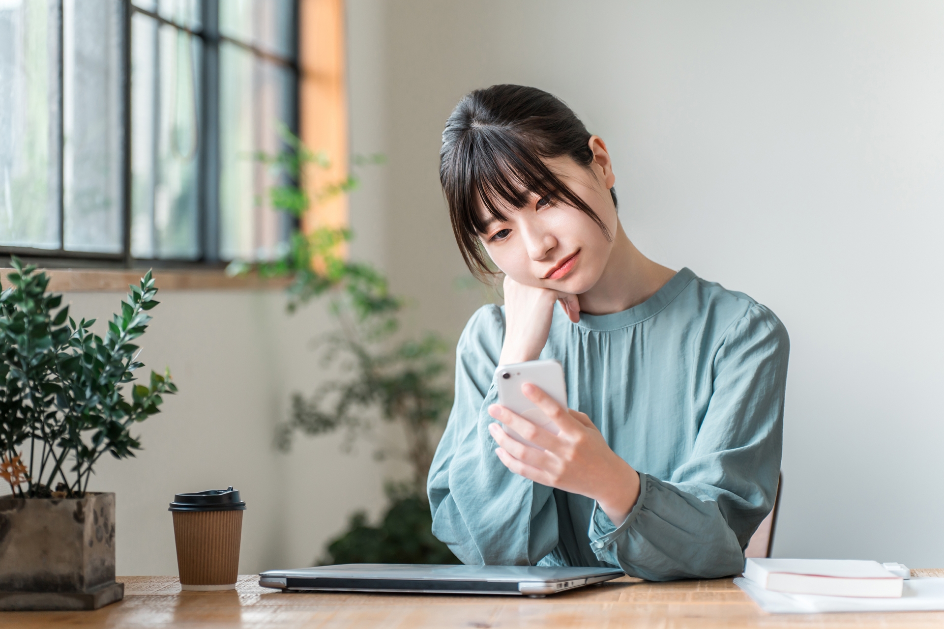スマホを見て首を傾げる女性